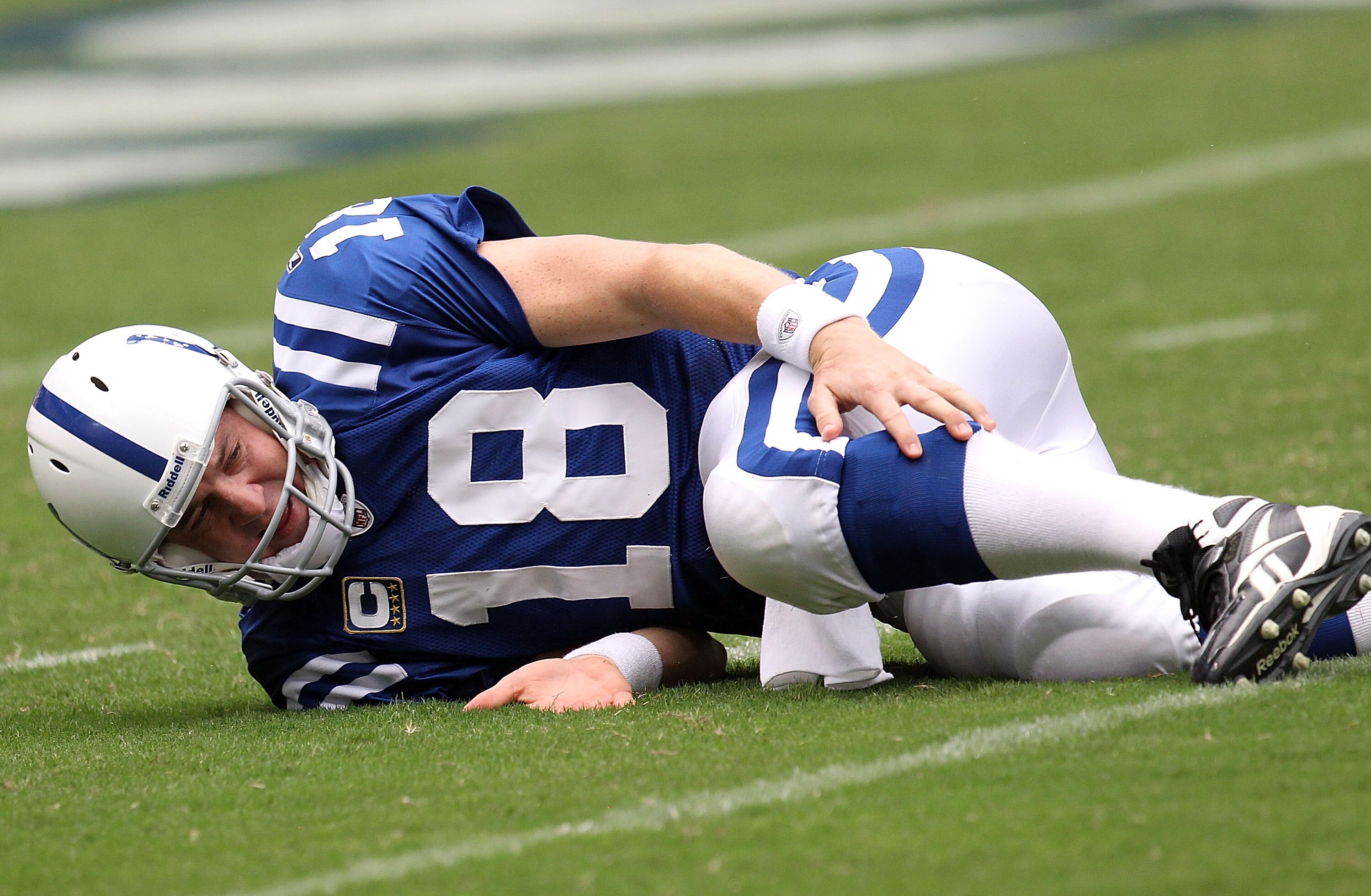 HOUSTON - SEPTEMBER 12:  Quarterback Peyton Manning #18 of the Indianapolis Colts reaches for his calf after a tackle by Mario Williams #90 of the Houston Texans during the NFL season opener at Reliant Stadium on September 12, 2010 in Houston, Texas.  (Ph