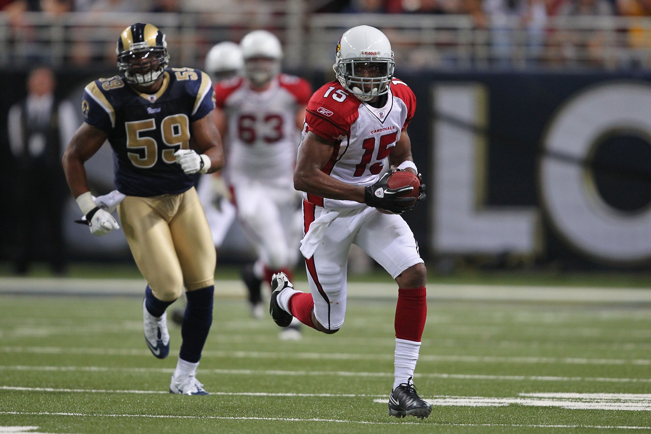 ST. LOUIS - SEPTEMBER 12: Steve Breaston #15 of the Arizona Cardinals runs up field against Larry Grant #59 of the St. Louis Rams during the NFL season opener at the Edward Jones Dome on September 12, 2010 in St. Louis, Missouri.  The Cardinals beat the R