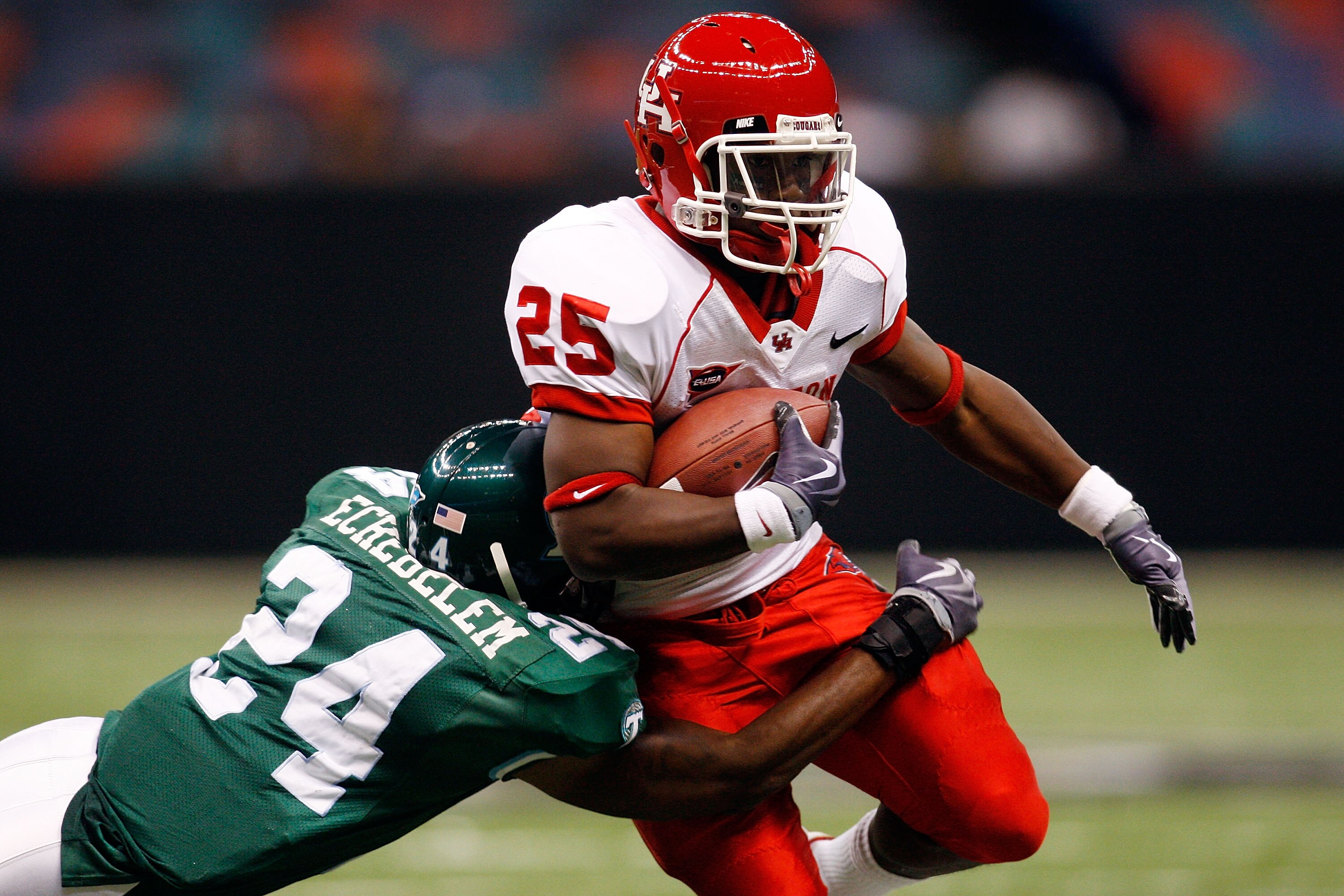 NEW ORLEANS - OCTOBER 17:  Bryce Beall #25 of the Houston Cougars is tackled by Chinonso Echebelem #24 of the Tulane Green Wave at the Louisiana Superdome on October 17, 2009 in New Orleans, Louisiana.  (Photo by Chris Graythen/Getty Images)