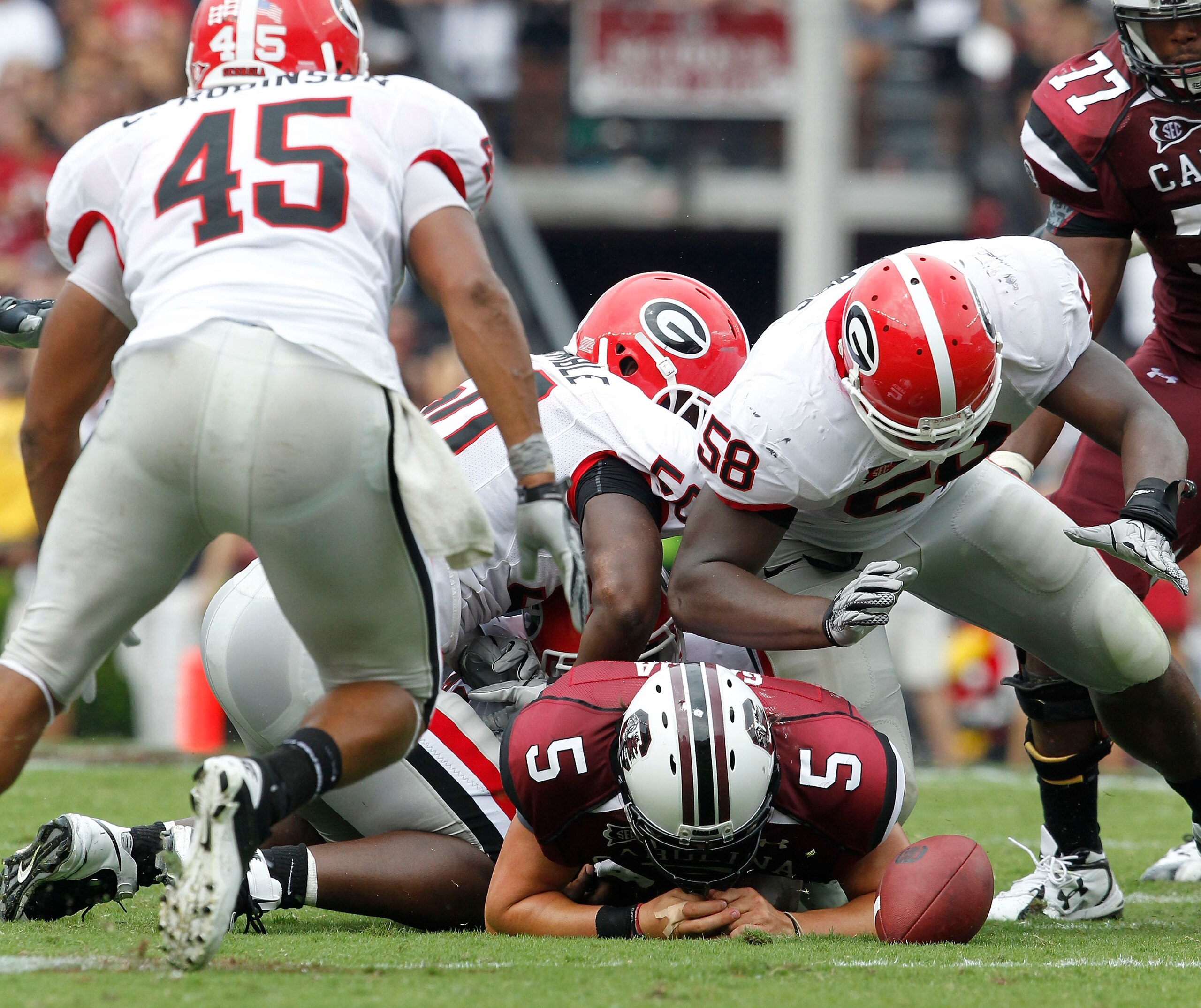 COLUMBIA, SC - SEPTEMBER 11: Quarterback Steven Garcia #5 of the South Carolina Gamecocks fumbles after being hit by defensive end Demarcus Dobbs #58 of the Georgia Bulldogs during the game at Williams-Brice Stadium on September 11, 2010 in Columbia, Sout