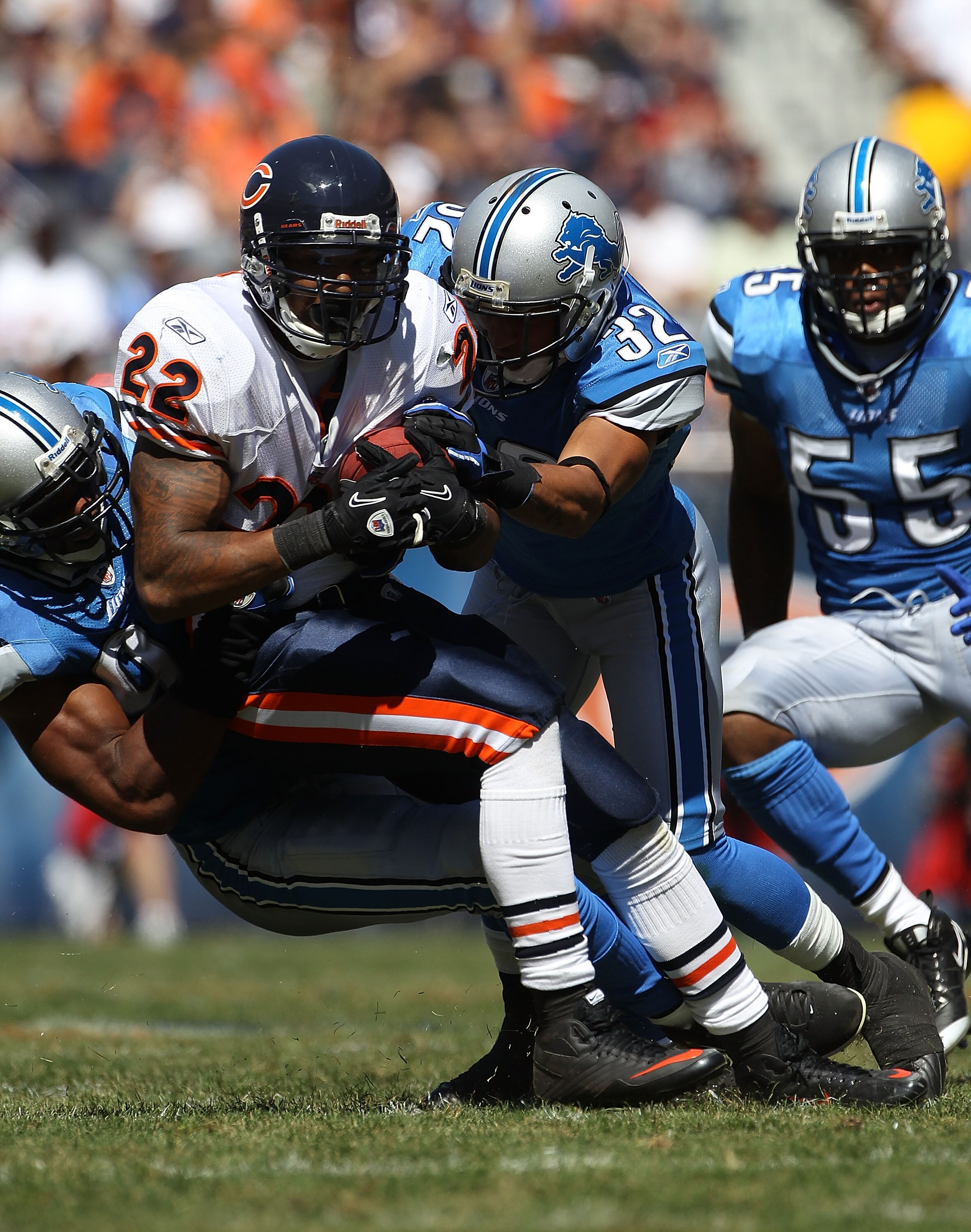 CHICAGO - SEPTEMBER 12: Matt Forte #22 of the Chicago Bears is tackled by Aaron Berry #32 and Corey Williams #99 of the Detroit Lions as Landon Johnson #55 closes in during the NFL season opening game at Soldier Field on September 12, 2010 in Chicago, Ill