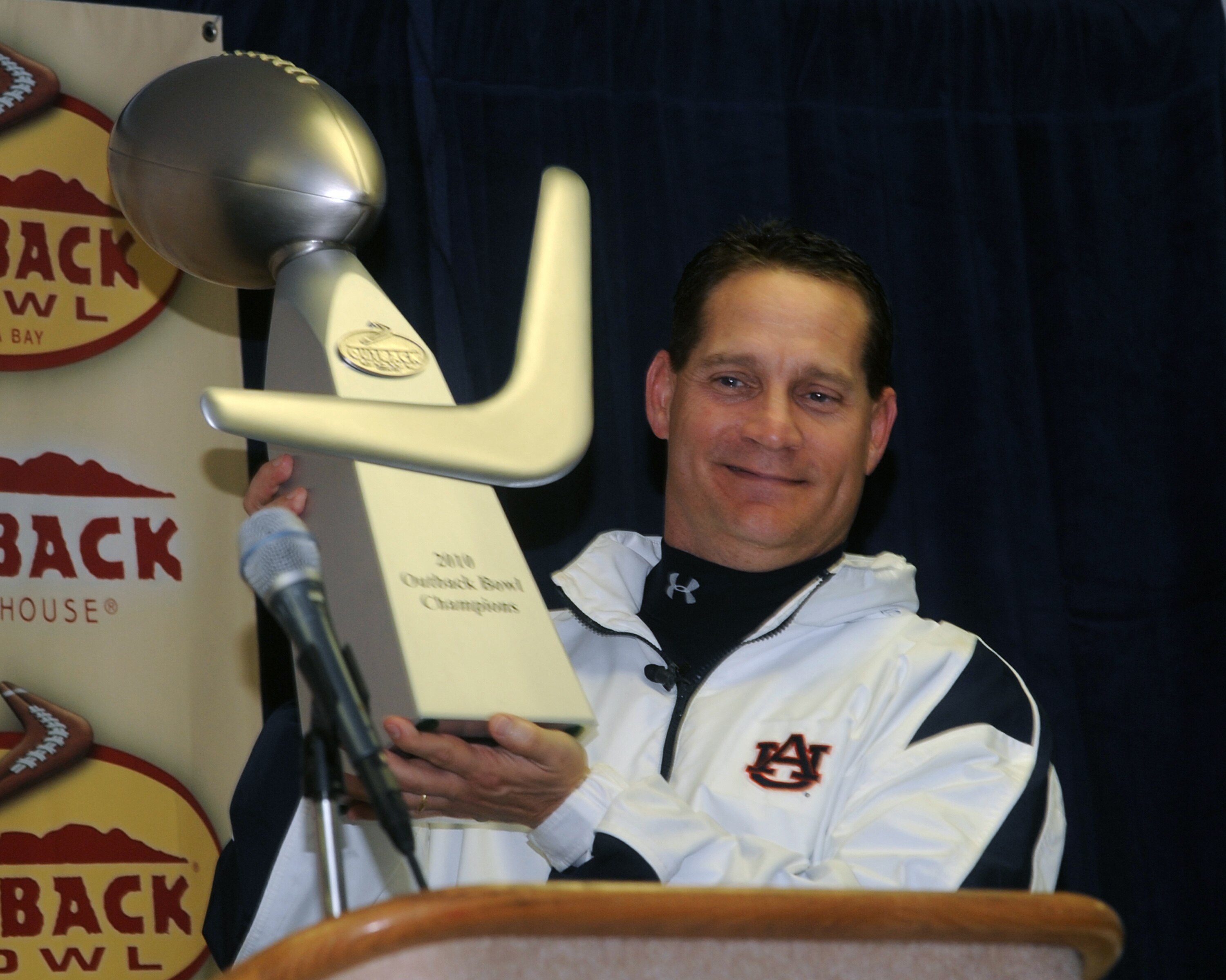 TAMPA, FL - JANUARY 1: Coach Gene Chizik of the Auburn Tigers holds the Outback trophy after an overtime victory against the Northwestern Wildcats in the Outback Bowl January 1, 2010 at Raymond James Stadium in Tampa, Florida.  (Photo by Al Messerschmidt/