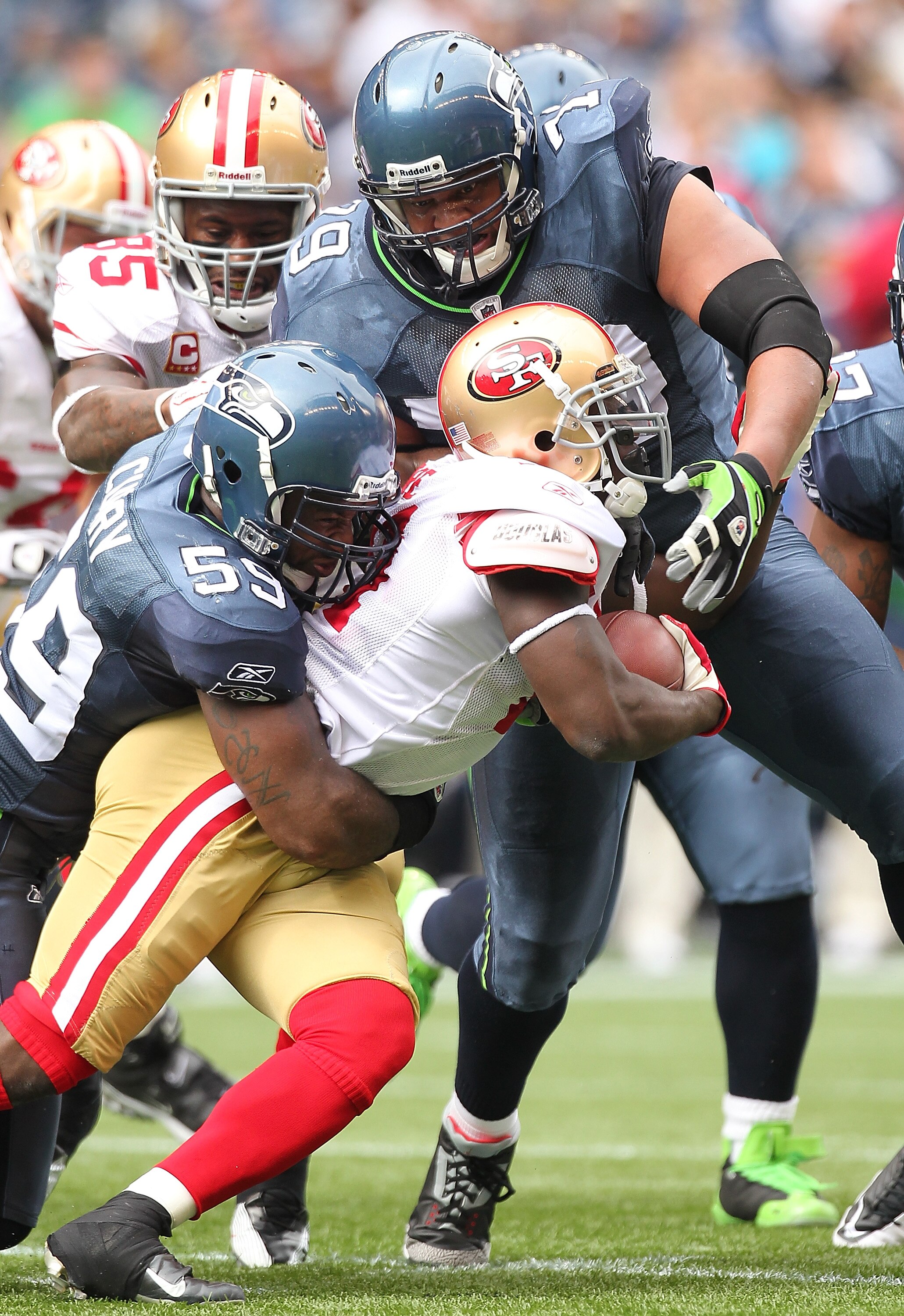 SEATTLE - SEPTEMBER 12:  Running back Frank Gore #21 of the San Francisco 49ers is wrapped up by Red Bryant #79 and Aaron Curry #59 during the NFL season opener against the Seattle Seahawks at Qwest Field on September 12, 2010 in Seattle, Washington. (Pho