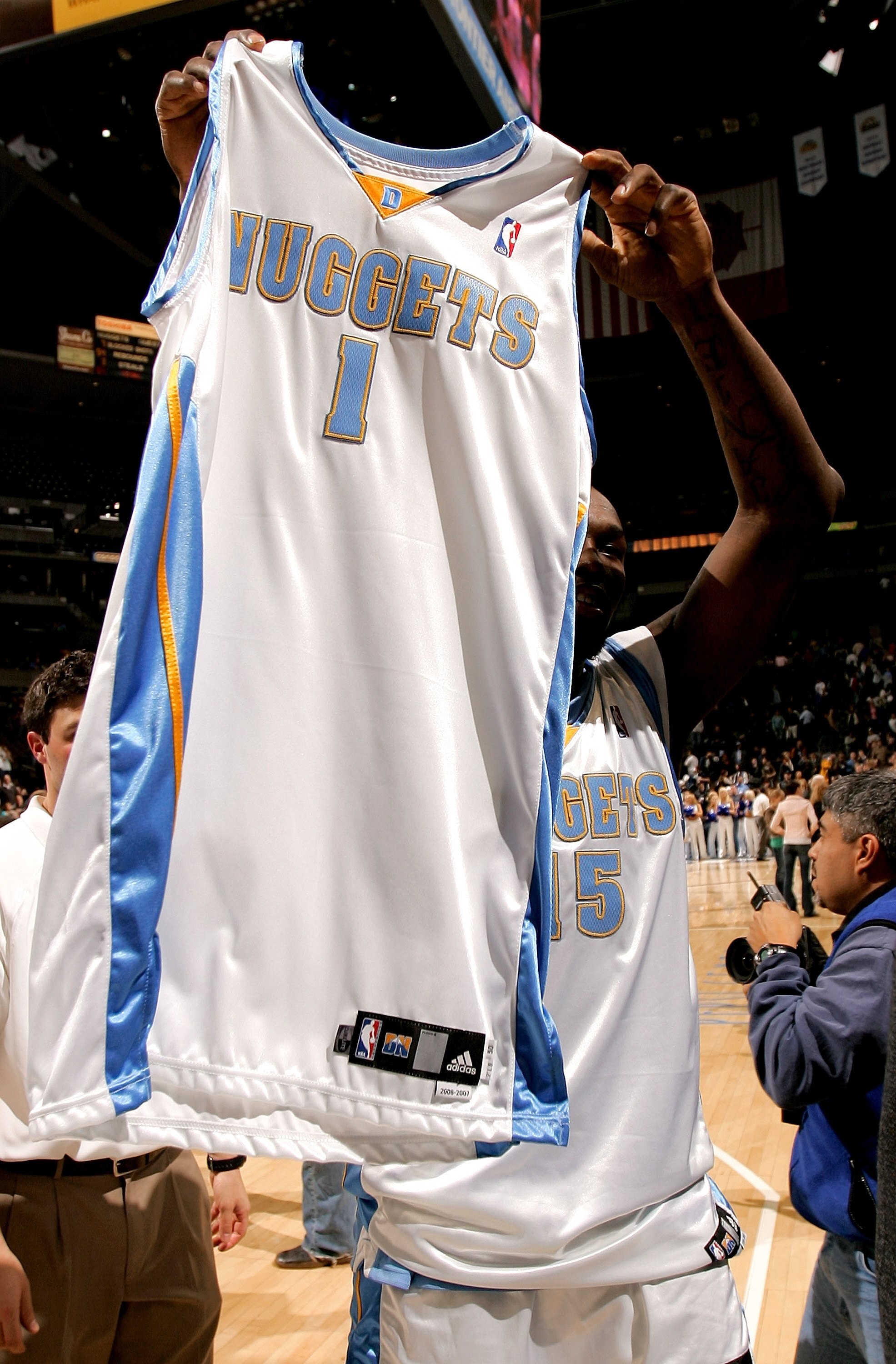 DENVER - DECEMBER 18:  Reggie Evans of the Denver Nuggets leaves the court wearing the #15 jersey of suspended Carmelo Anthony and carrying J.R. Smith's #1 jersey after the Nuggets defeated the Washington Wizards 117-108 during NBA on December 18, 2006 at