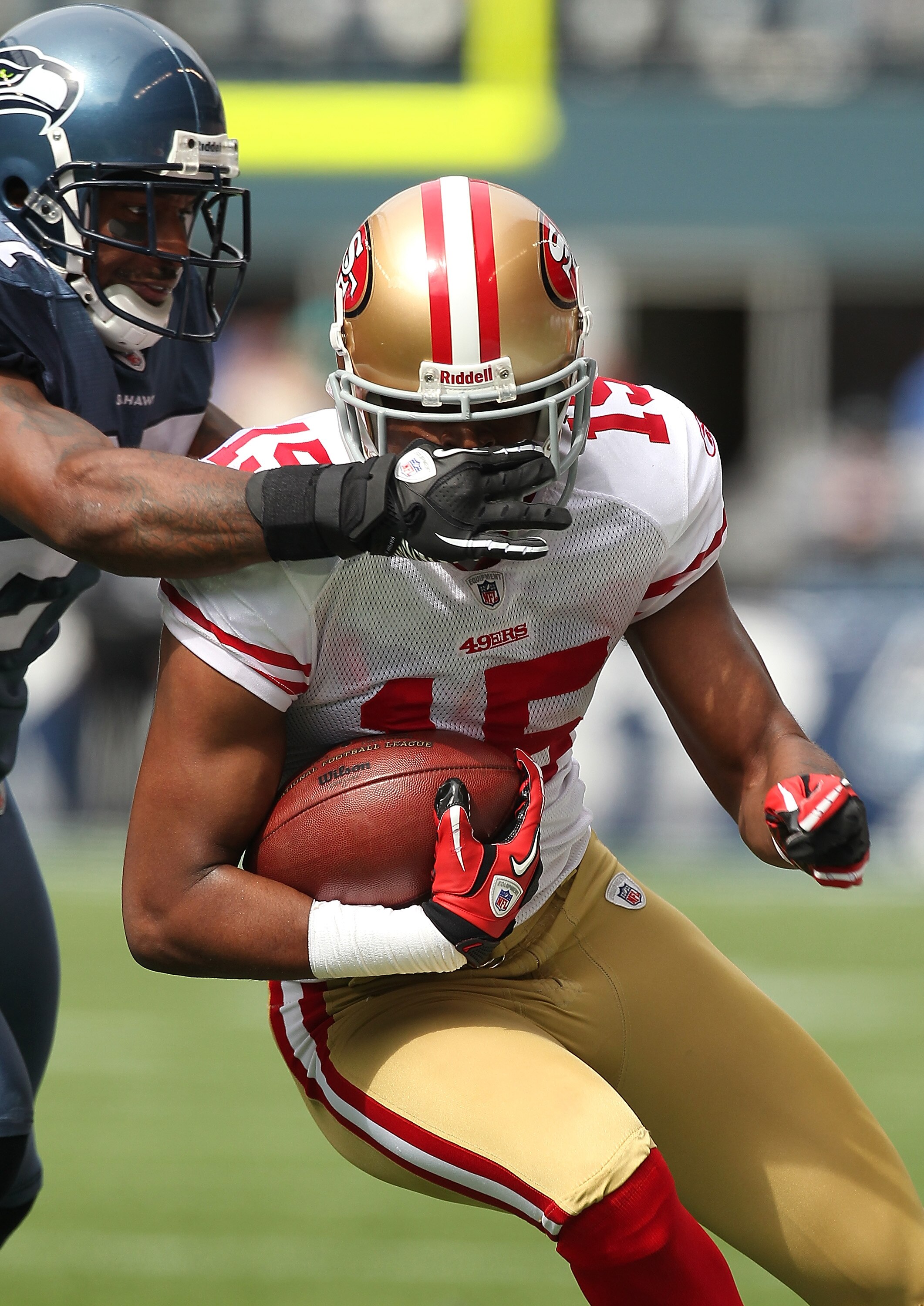 SEATTLE - SEPTEMBER 12:  Wide receiver Michael Crabtree #15 of the San Francisco 49ers is tackled by Jordan Babineaux #27 during the NFL season opener against the Seattle Seahawks at Qwest Field on September 12, 2010 in Seattle, Washington. (Photo by Otto
