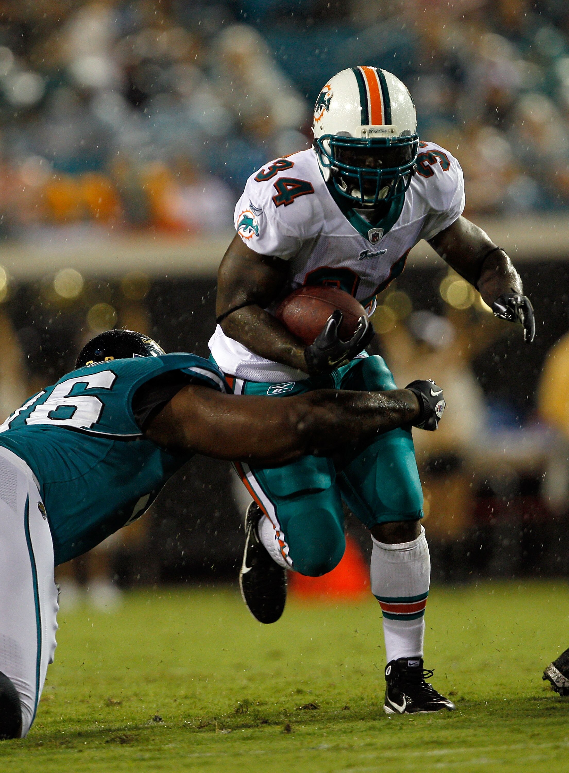 JACKSONVILLE, FL - AUGUST 21:  Terrance Knighton #96 of the Jacksonville Jaguars attempts to tackle Ricky Williams #34 of the Miami Dolphins during the preseason game at EverBank Field on August 21, 2010 in Jacksonville, Florida.  (Photo by Sam Greenwood/