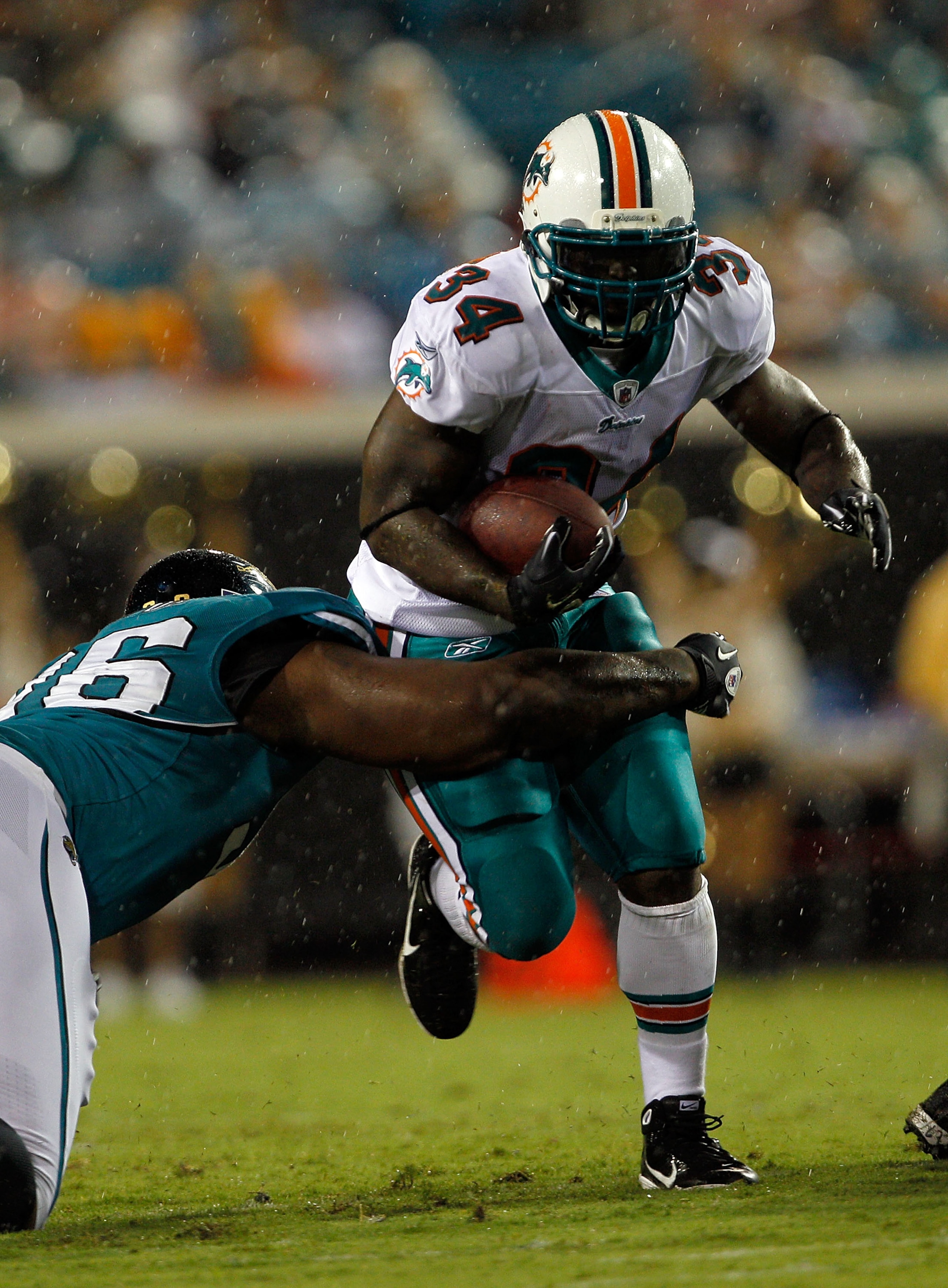 JACKSONVILLE, FL - AUGUST 21:  Terrance Knighton #96 of the Jacksonville Jaguars attempts to tackle Ricky Williams #34 of the Miami Dolphins during the preseason game at EverBank Field on August 21, 2010 in Jacksonville, Florida.  (Photo by Sam Greenwood/