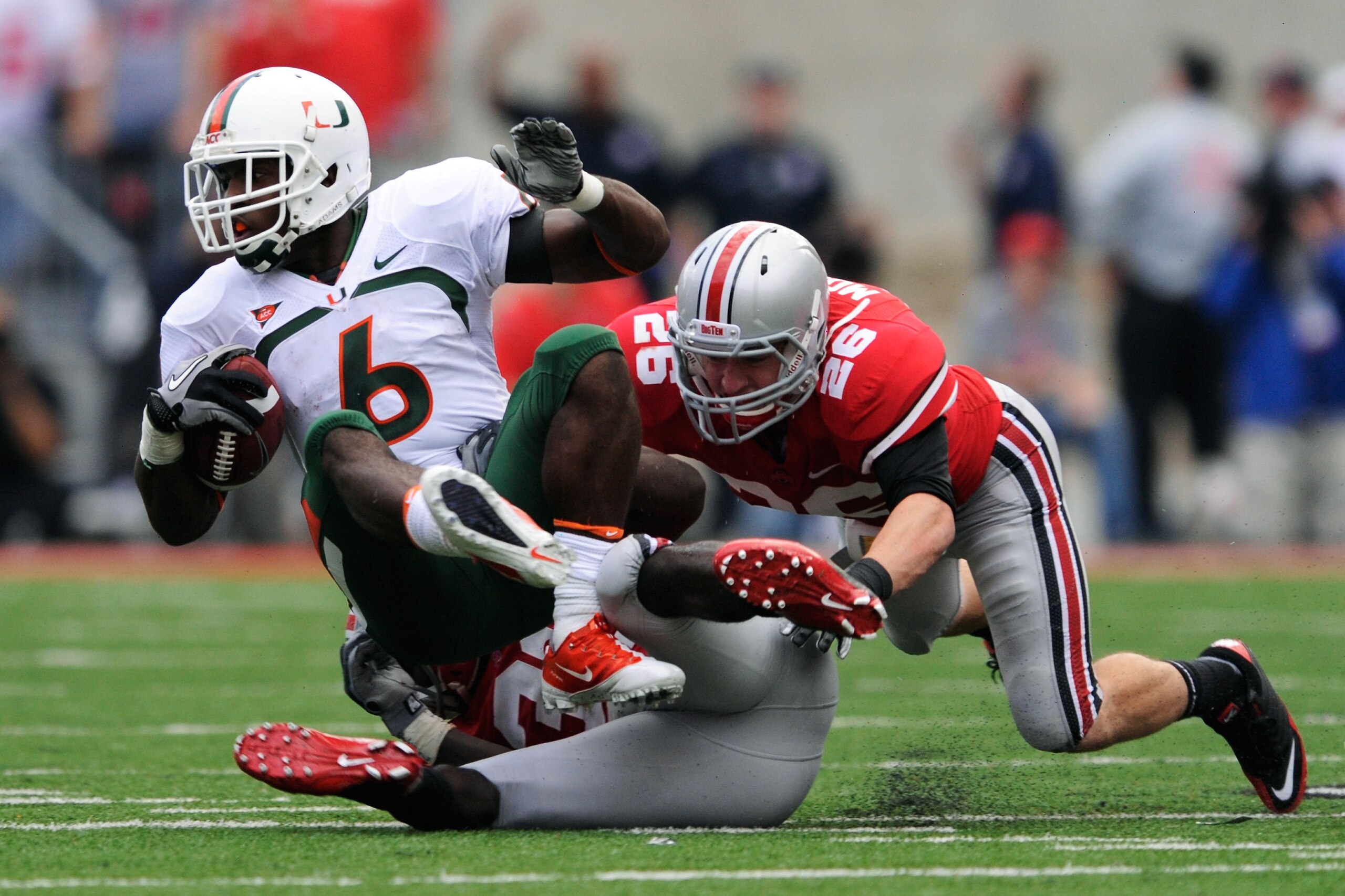 COLUMBUS, OH - SEPTEMBER 11:  Lamar Miller #6 of the Miami Hurricanes is hauled down by Brian Rolle #36 of the Ohio State Buckeyes and Tyler Moeller #26 of the Ohio State Buckeyes at Ohio Stadium on September 11, 2010 in Columbus, Ohio.  (Photo by Jamie S