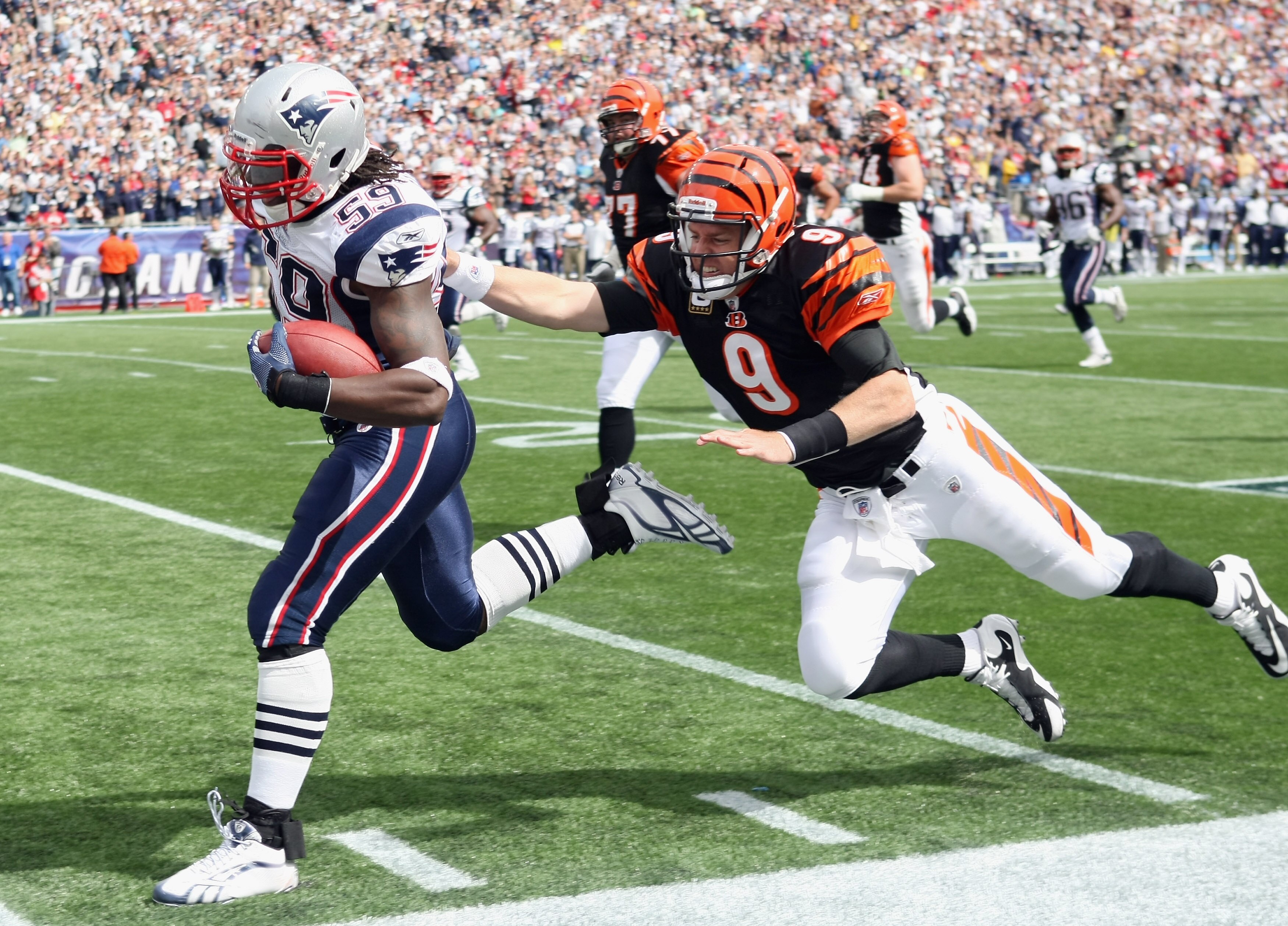 FOXBORO, MA - SEPTEMBER 12:  Gary Guyton #59 of the New England Patriots carries the ball in for a touchdown as Carson Palmer #9 of the Cincinnati Bengals tries to tackle during the NFL season opener on September 12, 2010 at Gillette Stadium in Foxboro, M