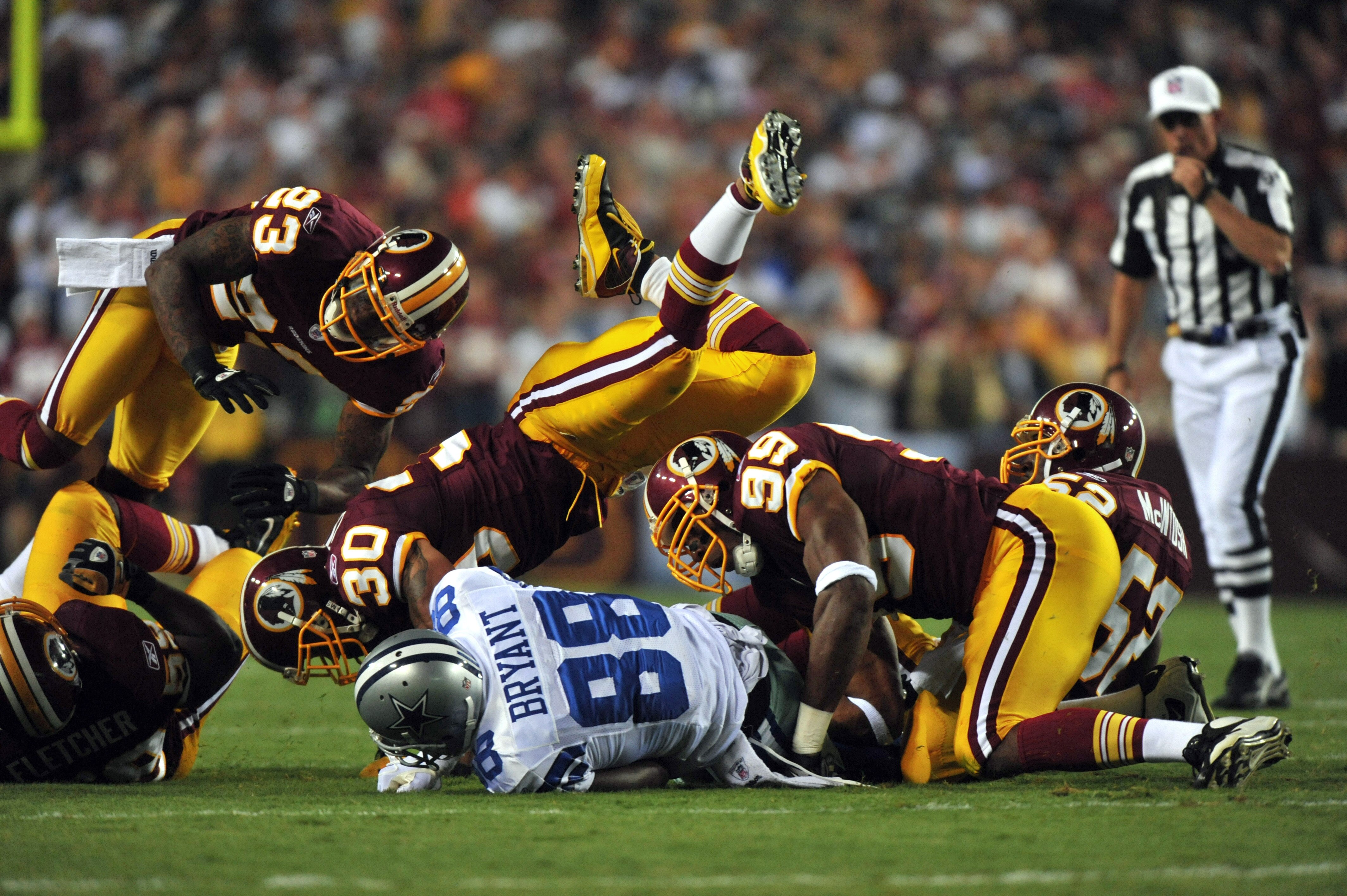 LANDOVER - SEPTEMBER 12:  LaRon Landry #30 of the Washington Redskins tackles Dez Bryant #88 of the Dallas Cowboys during the NFL season opener at FedExField on September 12, 2010 in Landover, Maryland. (Photo by Larry French/Getty Images)