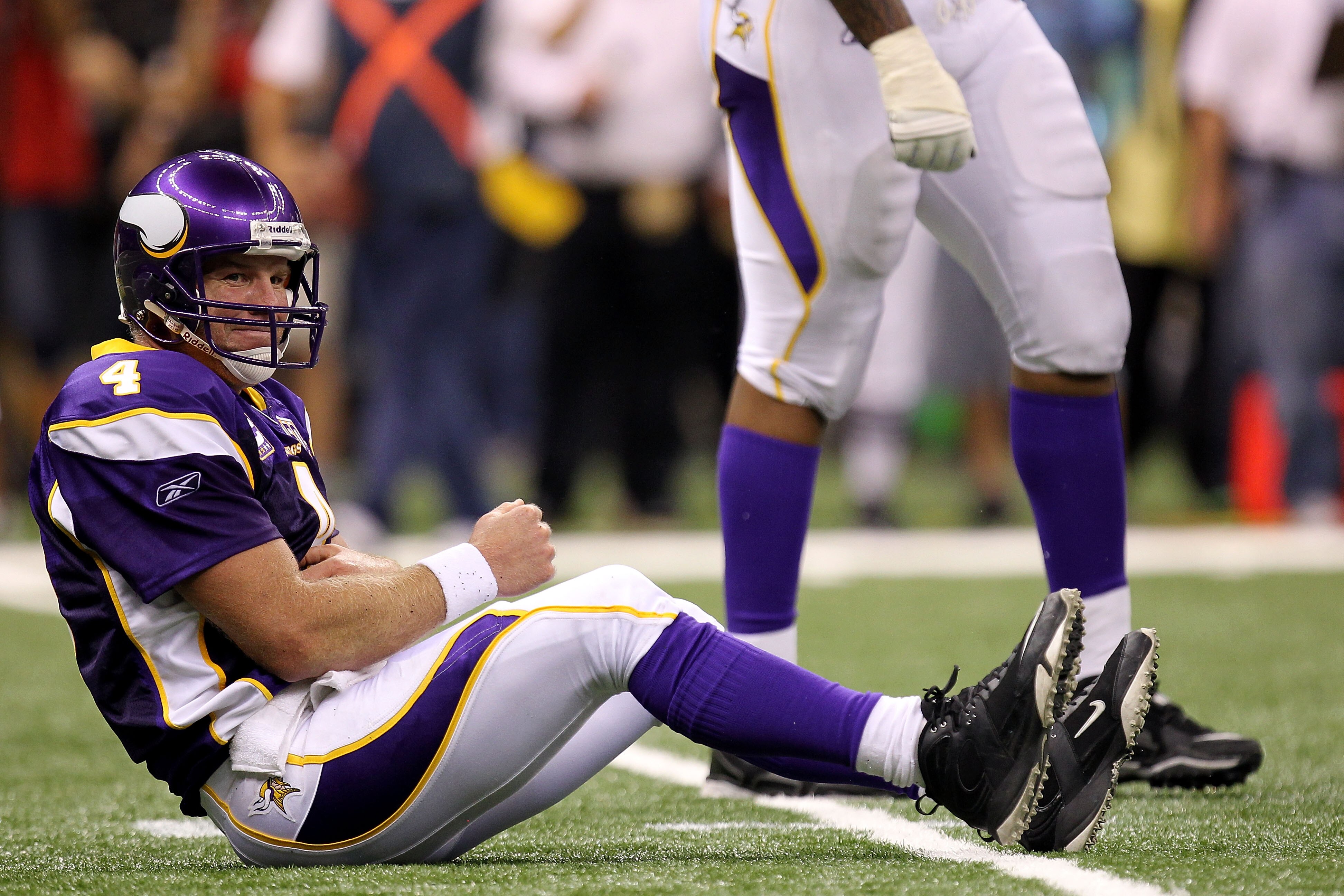 NEW ORLEANS - SEPTEMBER 09:  Quarterback Brett Favre #4 of the Minnesota Vikings grabs his torso as he lies on the turf after taking a hard hit from Roman Harper #41 of the New Orleans Saints at Louisiana Superdome on September 9, 2010 in New Orleans, Lou