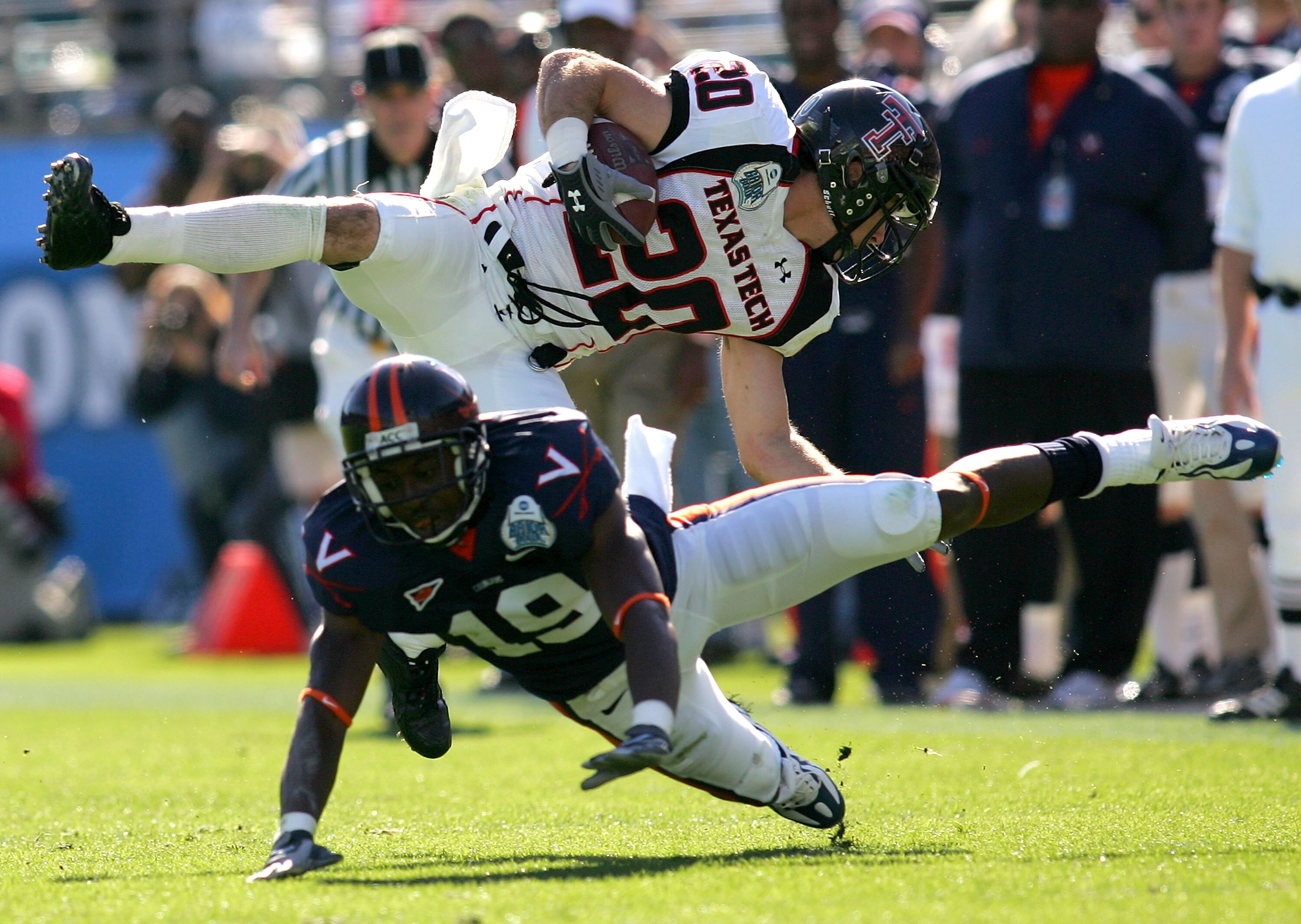 JACKSONVILLE, FL - JANUARY 01:  Danny Amendola #20 of the Texas Tech Red Raiders is tackled by  Ras-I Dowling #19 of the Virginia Cavaliers during the Gator Bowl at Jacksonville Municipal Stadium on January 1, 2008 in Jacksonville, Florida.  (Photo by Sam