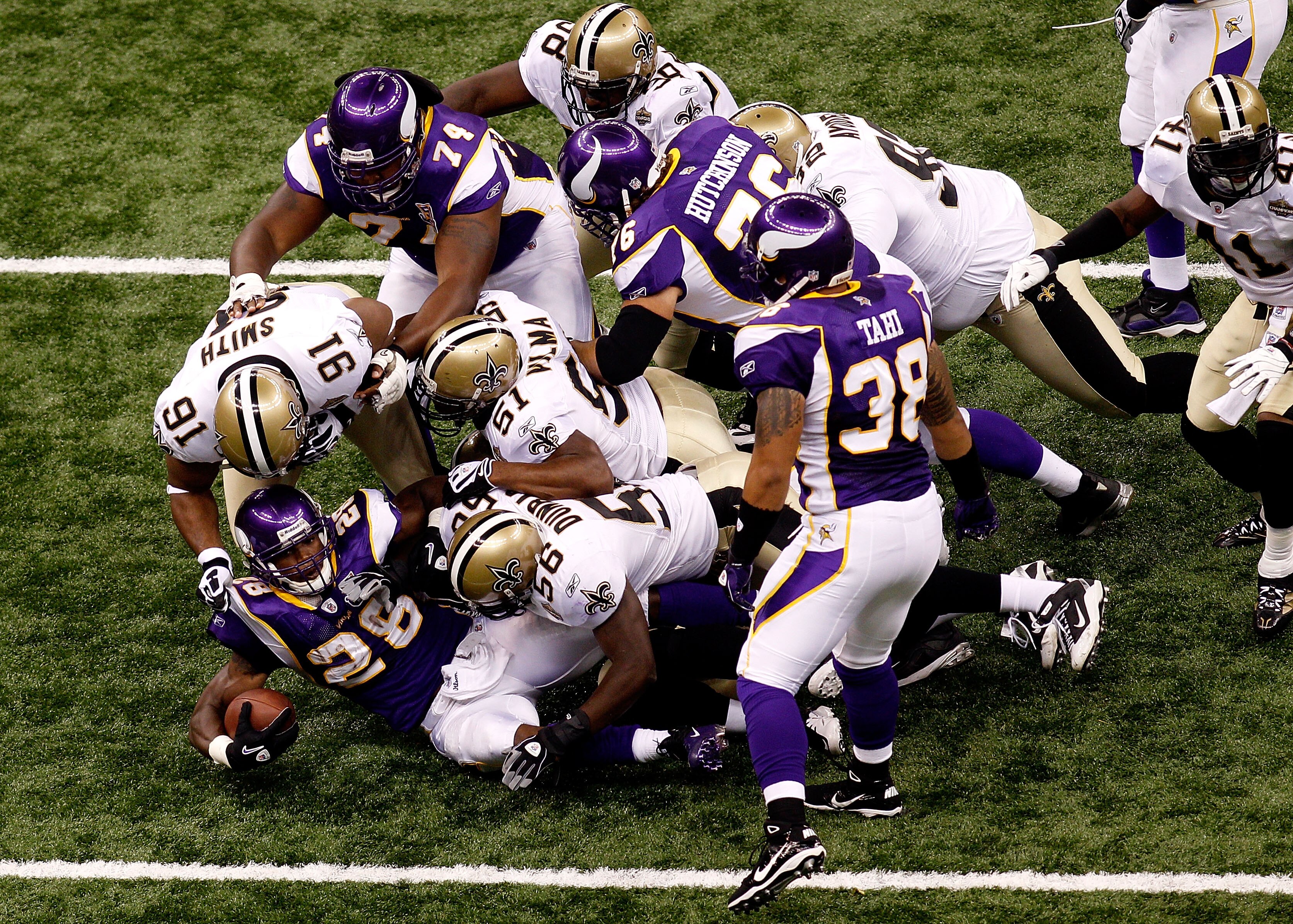 NEW ORLEANS - SEPTEMBER 09:  Adrian Peterson #28 of the Minnesota Vikings is tackled by Will Smith #91, Jonathan Vilma #51 and Jo-Lonn Dunbar #56 of the New Orleans Saints at Louisiana Superdome on September 9, 2010 in New Orleans, Louisiana.  (Photo by C
