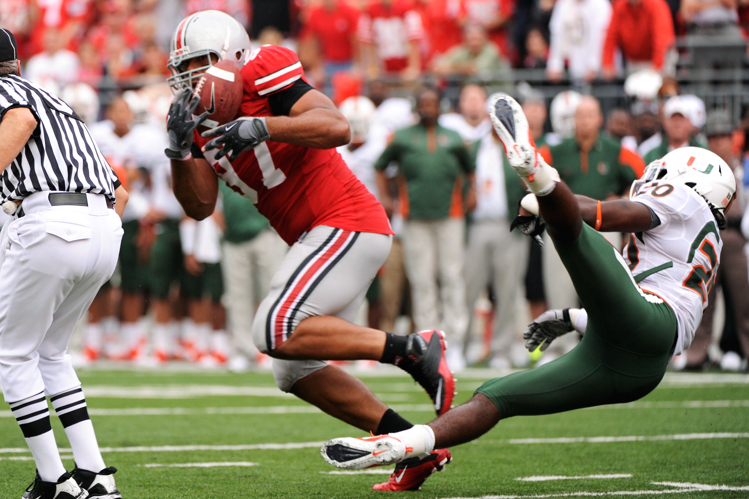 COLUMBUS, OH - SEPTEMBER 11:  Cameron Heyward #97 of the Ohio State Buckeyes steps in front of Damien Berry #20 of the Miami Hurricanes to intercept a pass at Ohio Stadium on September 11, 2010 in Columbus, Ohio. Ohio State intercepted Miami four times en