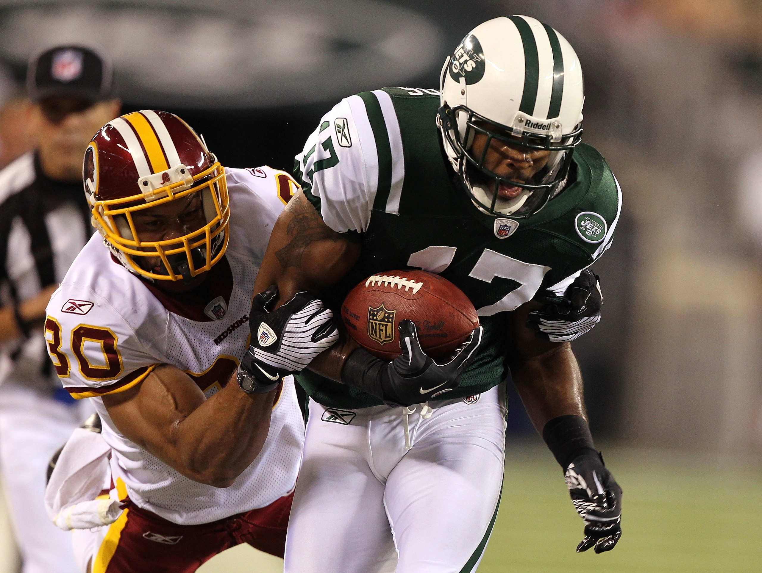 EAST RUTHERFORD, NJ - AUGUST 27:  Braylon Edwards #17 of the New York Jets is tackled by LaRon Landry #30 of the Washington Redskins  during their preseason game on August 27, 2010 at the New Meadowlands Stadium  in East Rutherford, New Jersey.  (Photo by