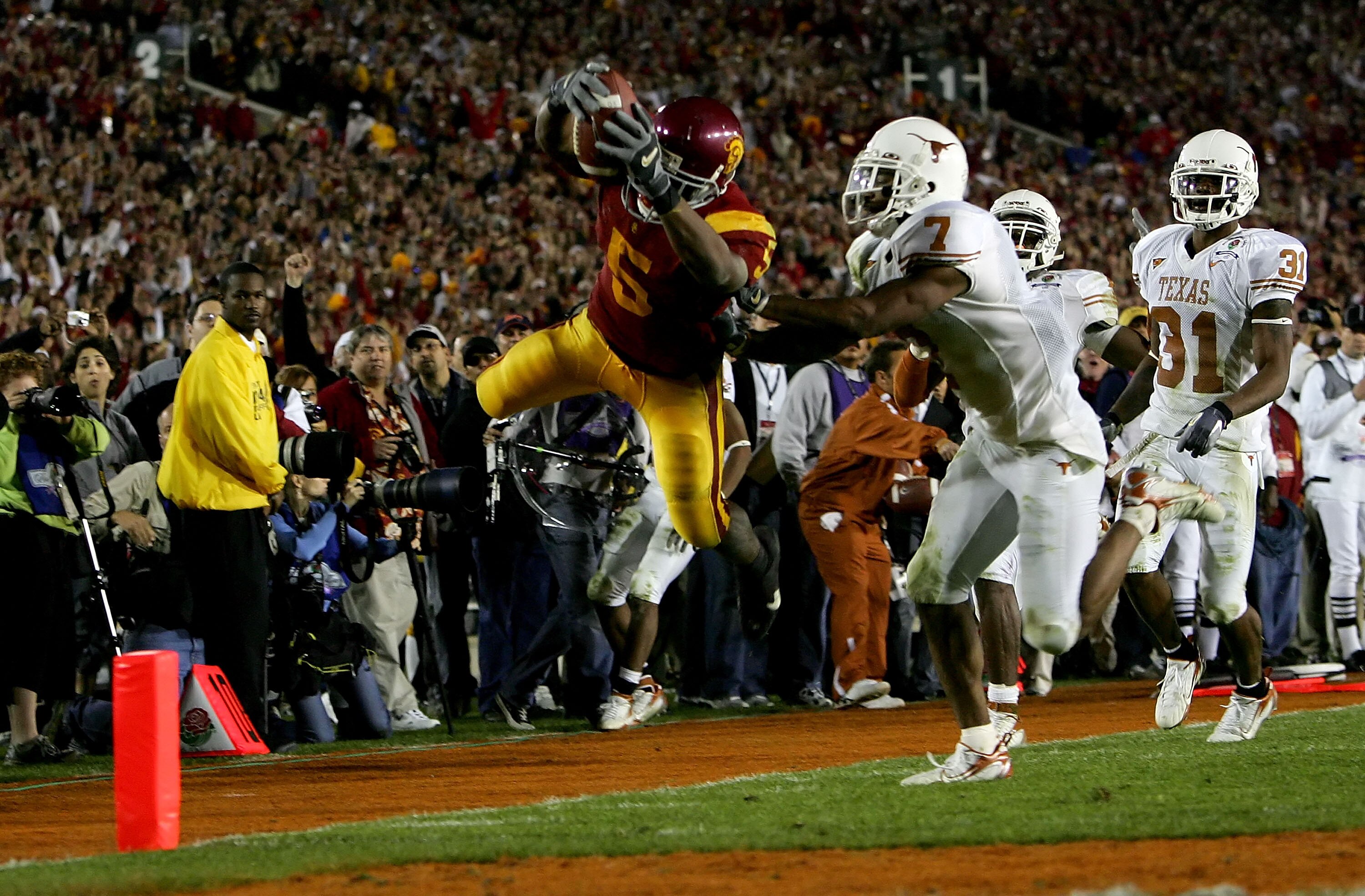 PASADENA, CA - JANUARY 04: Reggie Bush #5 of the USC Trojans dives over the goal line as he scores a 26 yard touchdown in the fourth quarter of the BCS National Championship Rose Bowl Game against the Texas Longhorns at the Rose Bowl on January 4, 2006 i PASADENA, CA - JANUARY 04: Reggie Bush #5 of the USC Trojans dives over the goal line as he scores a 26 yard touchdown in the fourth quarter of the BCS National Championship Rose Bowl Game against the Texas Longhorns at the Rose Bowl on January 4, 2006 i