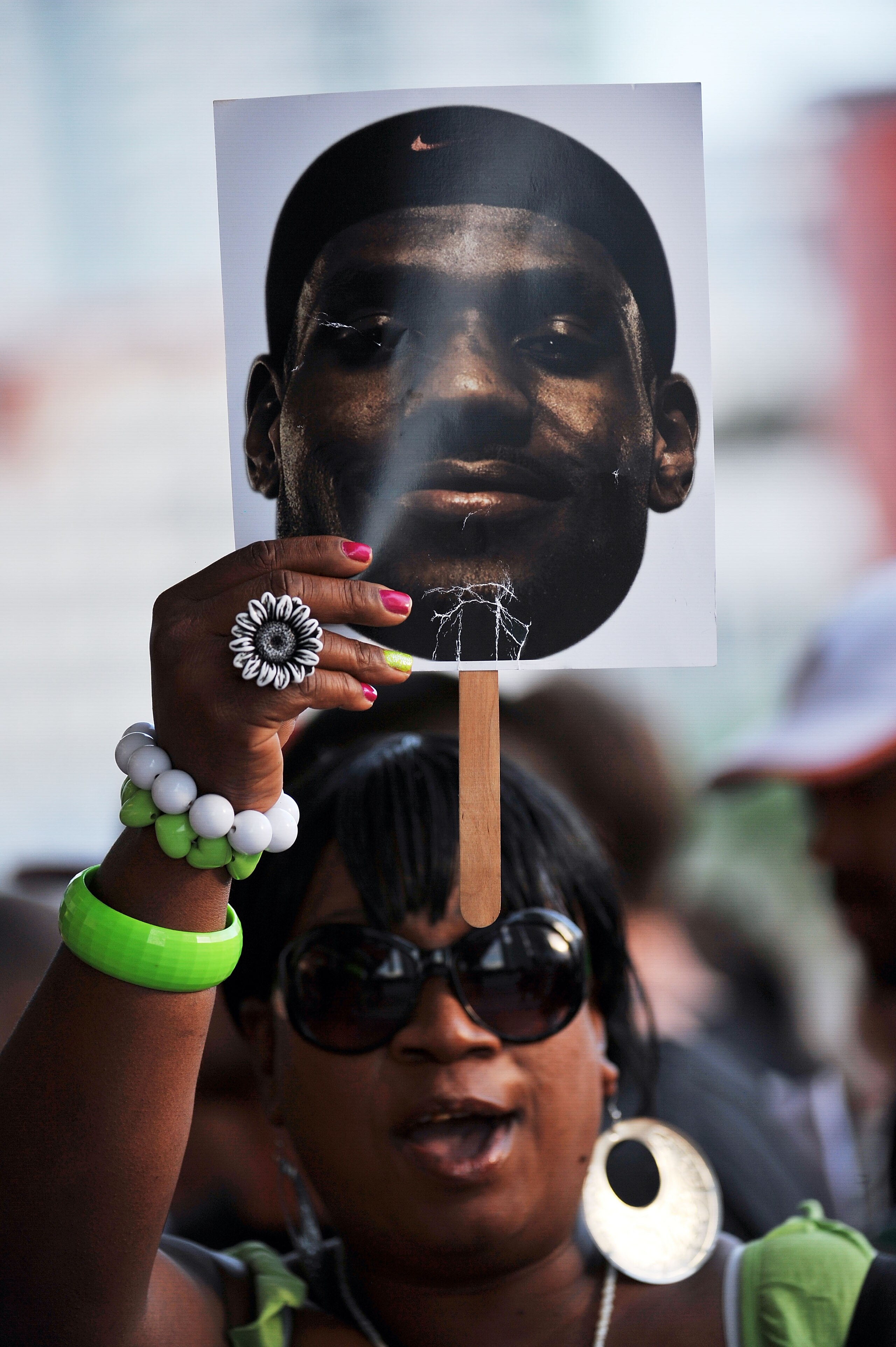 MIAMI - JULY 09:  A ticketed guest holds up the face of LeBron James before Chris Bosh #1, Dwyane Wade #3 and LeBron James #6 of the Miami Heat are presented to fans during a welcome party at American Airlines Arena on July 9, 2010 in Miami, Florida.  (Ph