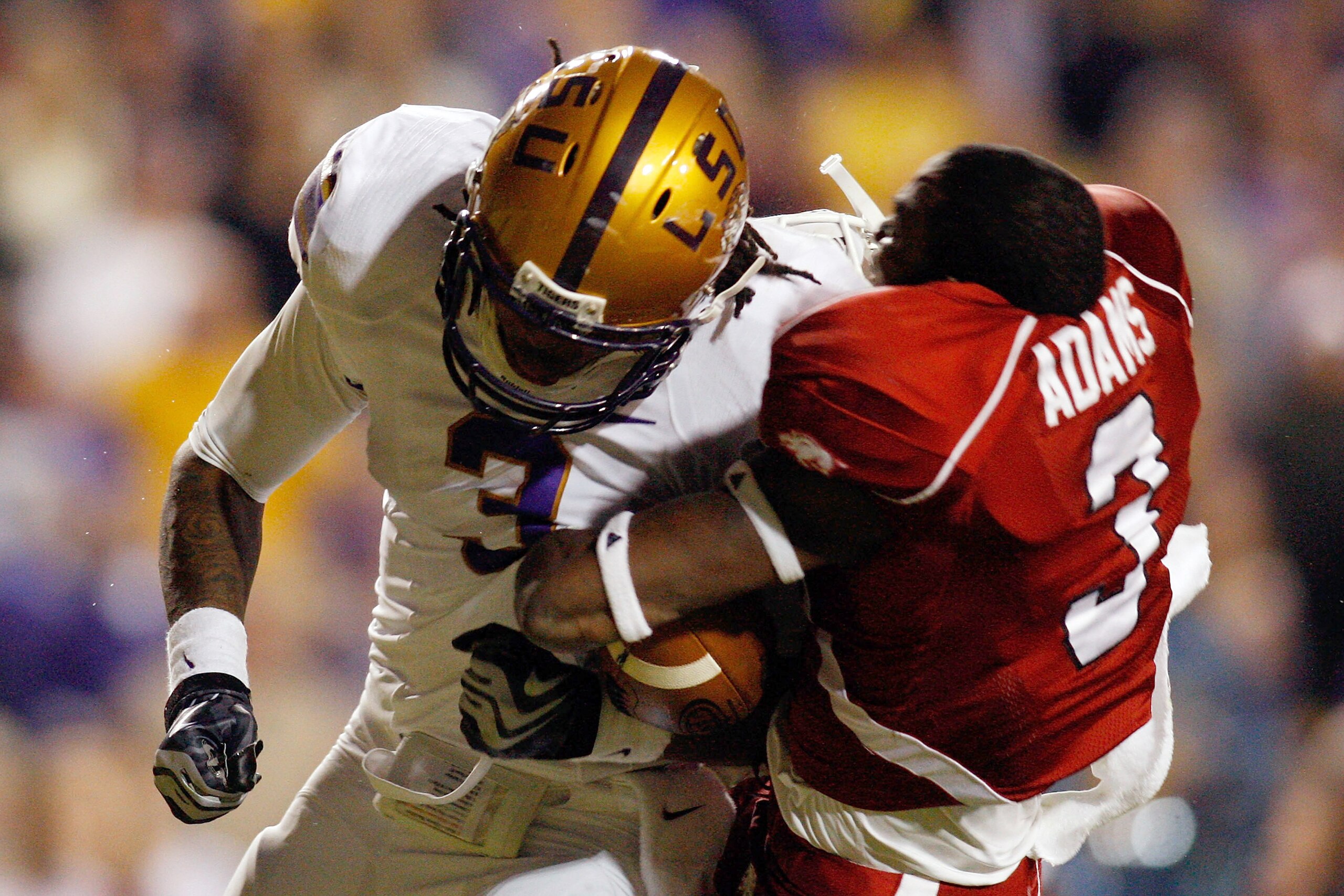 BATON ROUGE, LA - NOVEMBER 28:  Chad Jones #3 of the LSU Tigers knocks off the helmet of Joe Adams #3 of the Arkansas Razorbacks at Tiger Stadium on November 28, 2009 in Baton Rouge, Louisiana.  The Tigers defeated the Razorbacks 33-30 in overtime.   (Pho