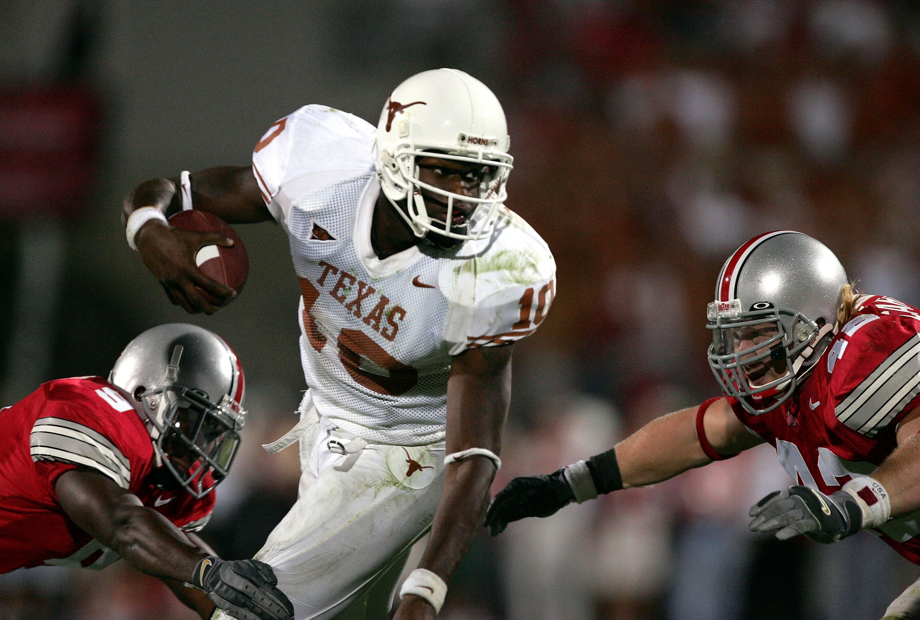 COLUMBUS, OH - SEPTEMBER 10:  Quarterback Vince Young #10 of the Texas Longhorns tries to slip the tackle of strong safety Donte Whitner #9 and linebacker Bobby Carpenter #42 of the Ohio State Buckeyes during the fourth quarter at Ohio Stadium on Septembe