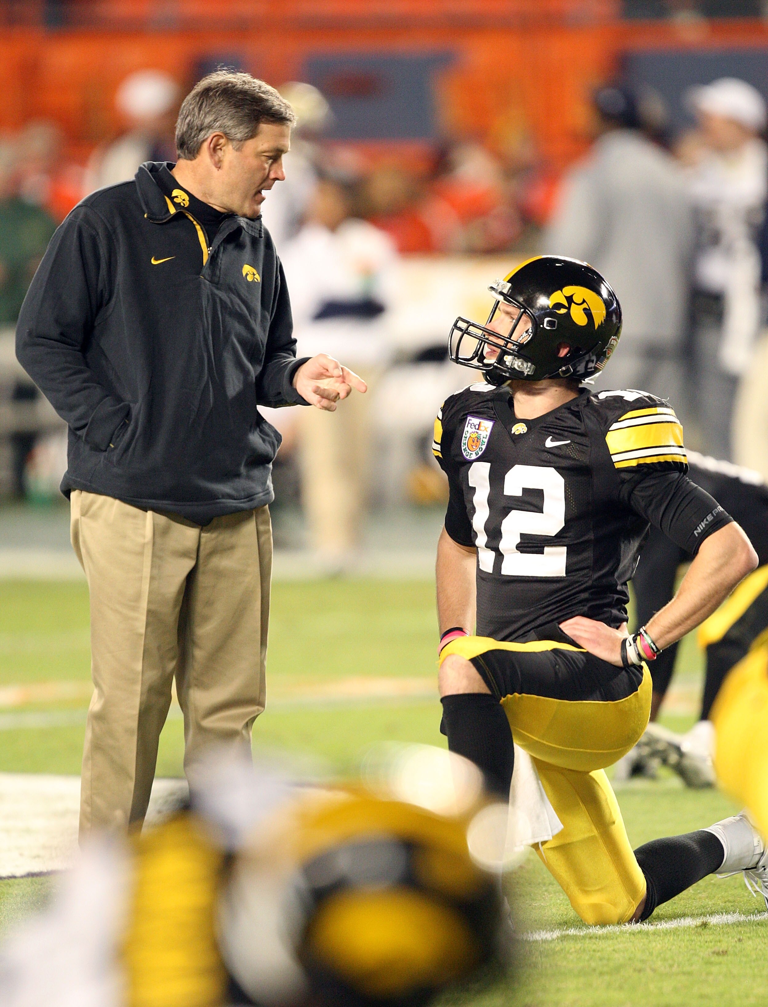 MIAMI GARDENS, FL - JANUARY 05:  Head coach Kirk Ferentz and quarterback Ricky Stanzi #12 of the Iowa Hawkeyes talks on the field during warm ups against the Georgia Tech Yellow Jackets during the FedEx Orange Bowl at Land Shark Stadium on January 5, 2010