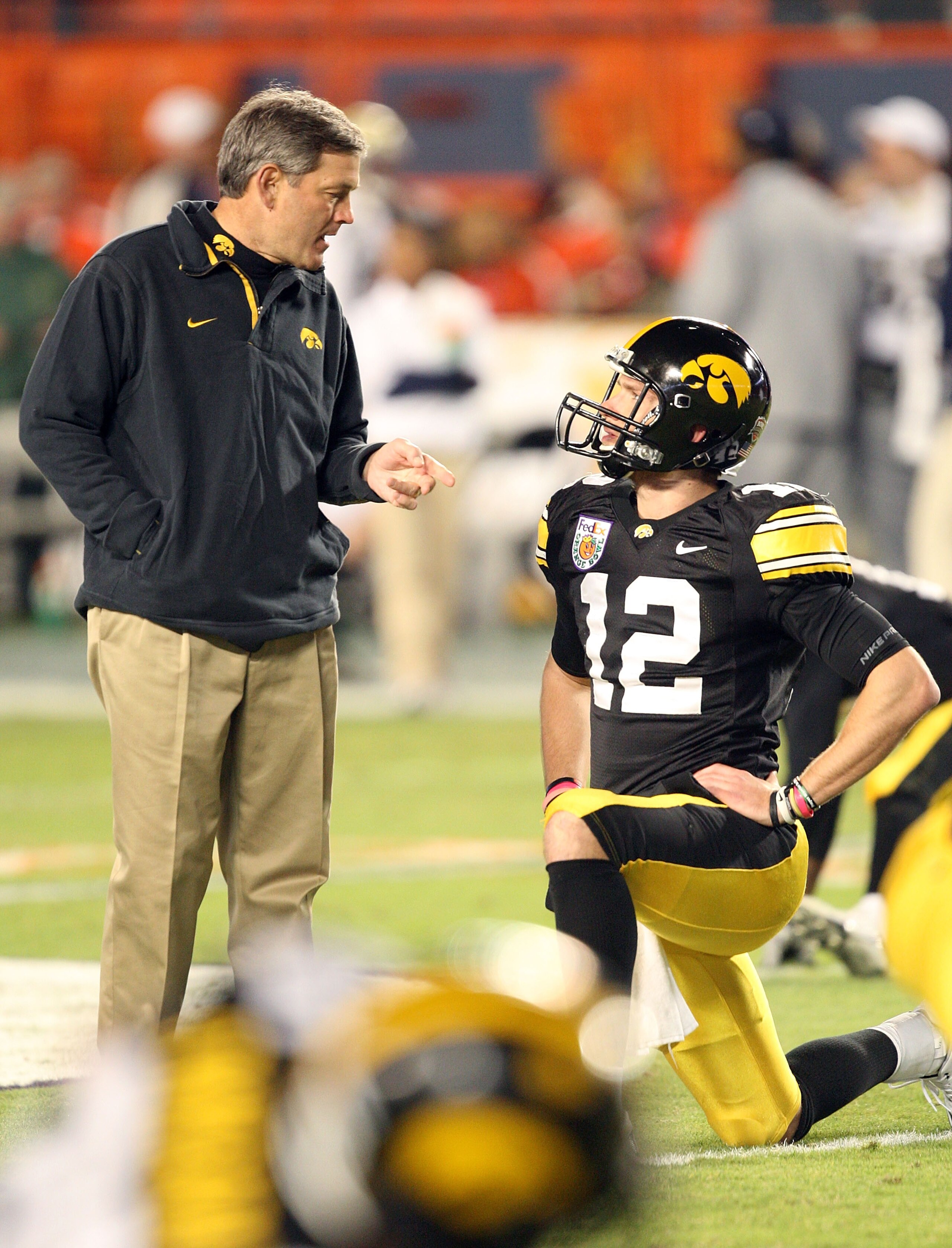 MIAMI GARDENS, FL - JANUARY 05:  Head coach Kirk Ferentz and quarterback Ricky Stanzi #12 of the Iowa Hawkeyes talks on the field during warm ups against the Georgia Tech Yellow Jackets during the FedEx Orange Bowl at Land Shark Stadium on January 5, 2010
