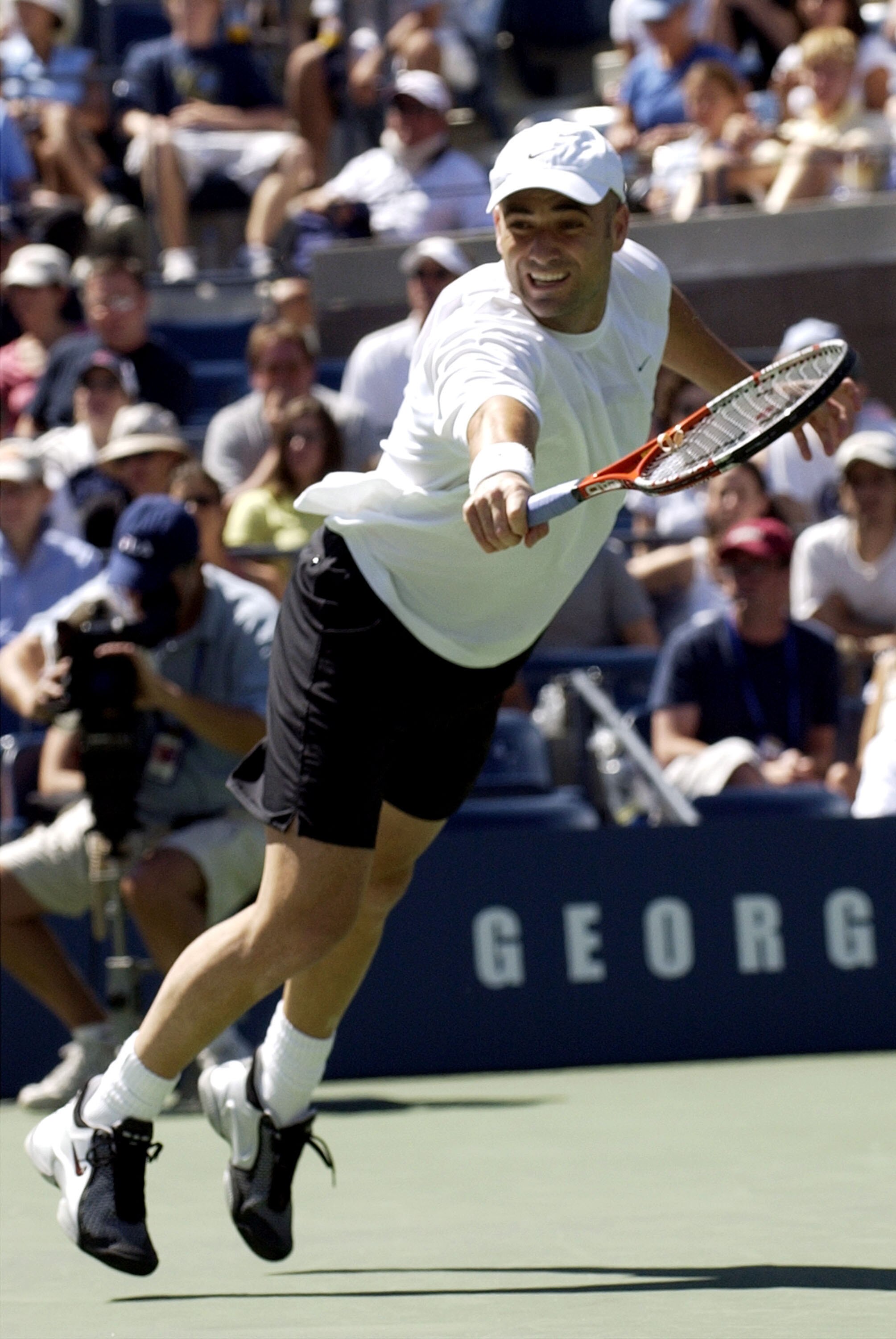 Andre Agassi, U. S. A., stretches for a backhand Sunday, August 31, 2003  at the U. S. Open in New York.  Agassi, the top seed in the tournament,  defeated Yevgeny Kafelnikov in three sets in a match continued after Saturday's rain. (Photo by A. Messersch
