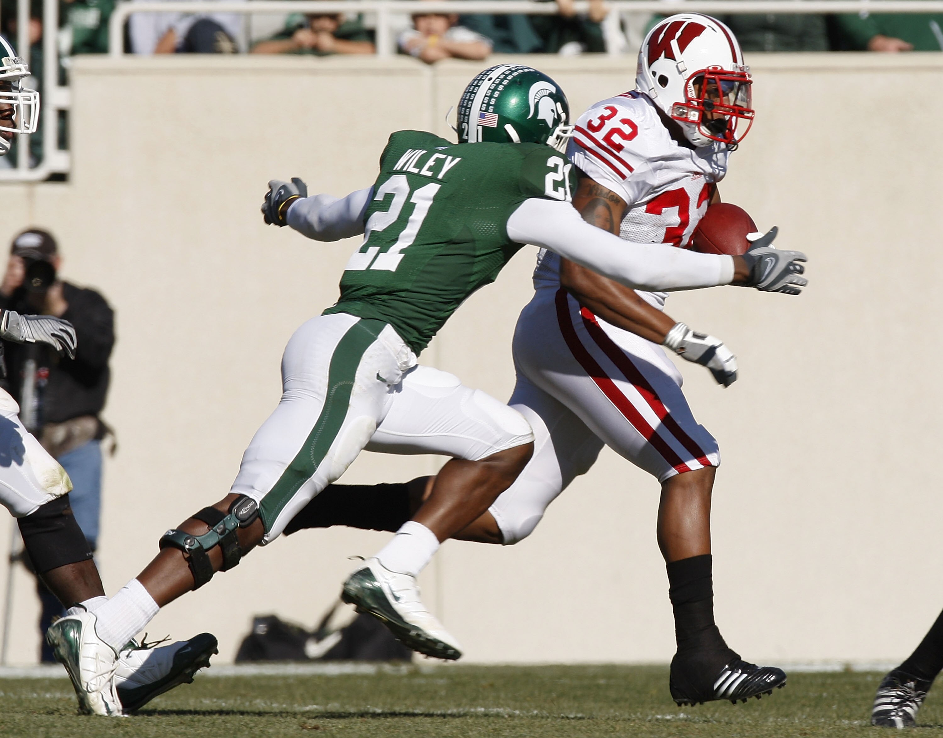 EAST LANSING, MI - NOVEMBER 01: John Clay #32 of the Wisconsin Badgers tries to get around the tackle of Otis Wiley #21 of the Michigan State Spartans during a second quarter run on November 1, 2008 at Spartan Stadium in East Lansing, Michigan.  (Photo by