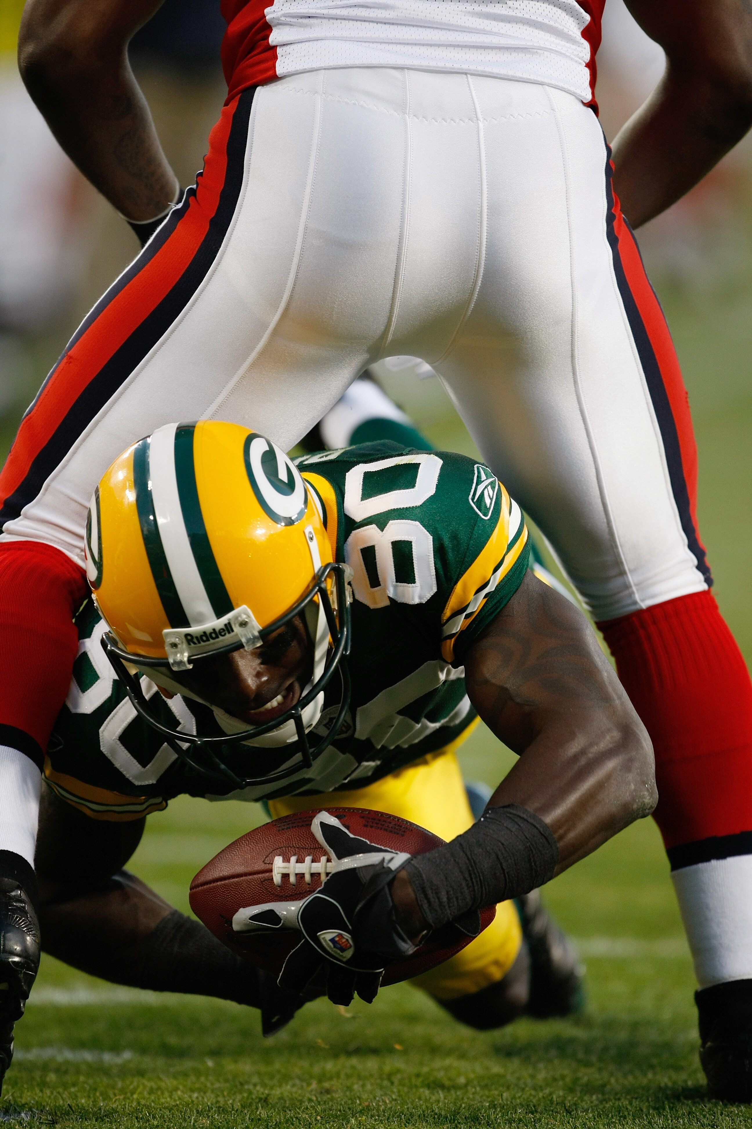 GREEN BAY, WI - AUGUST 22: Wide receiver Donald Driver #80 of the Green Bay Packers dives for additional yardage through a defenders legs against the Buffalo Bills at Lambeau Field on August 22, 2009 in Green Bay. Wisconsin.  (Photo by Scott Boehm/Getty I