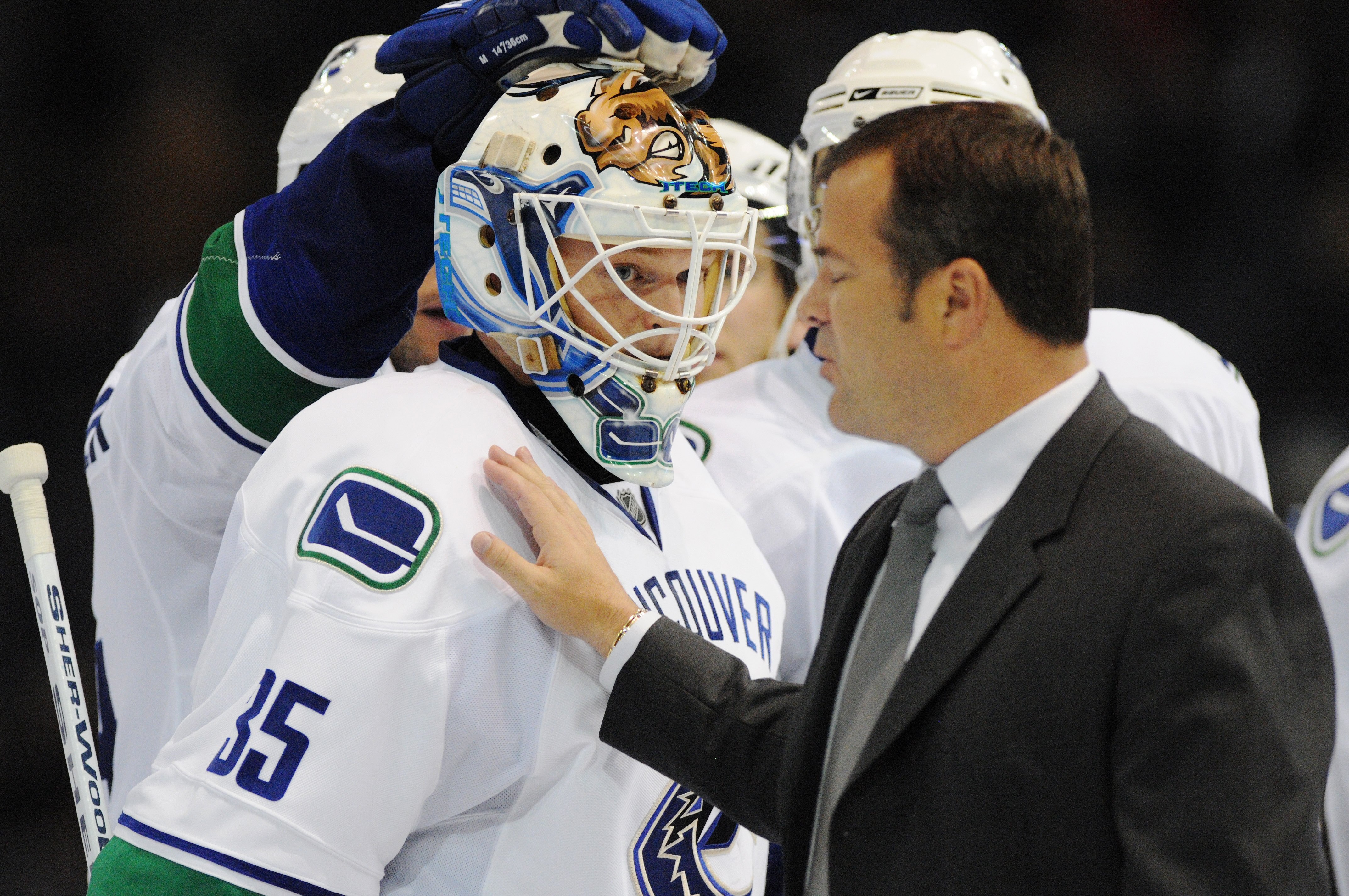 EDMONTON, AB - SEPTEMBER 22:  Head Coach Alain Vigneault of the Vancouver Canucks congratulates goaltender Cory Schneider #35 of the Vancouver Canucks after the shoot-out overtime against the Edmonton Oilers during an NHL preseason game on September 22, 2