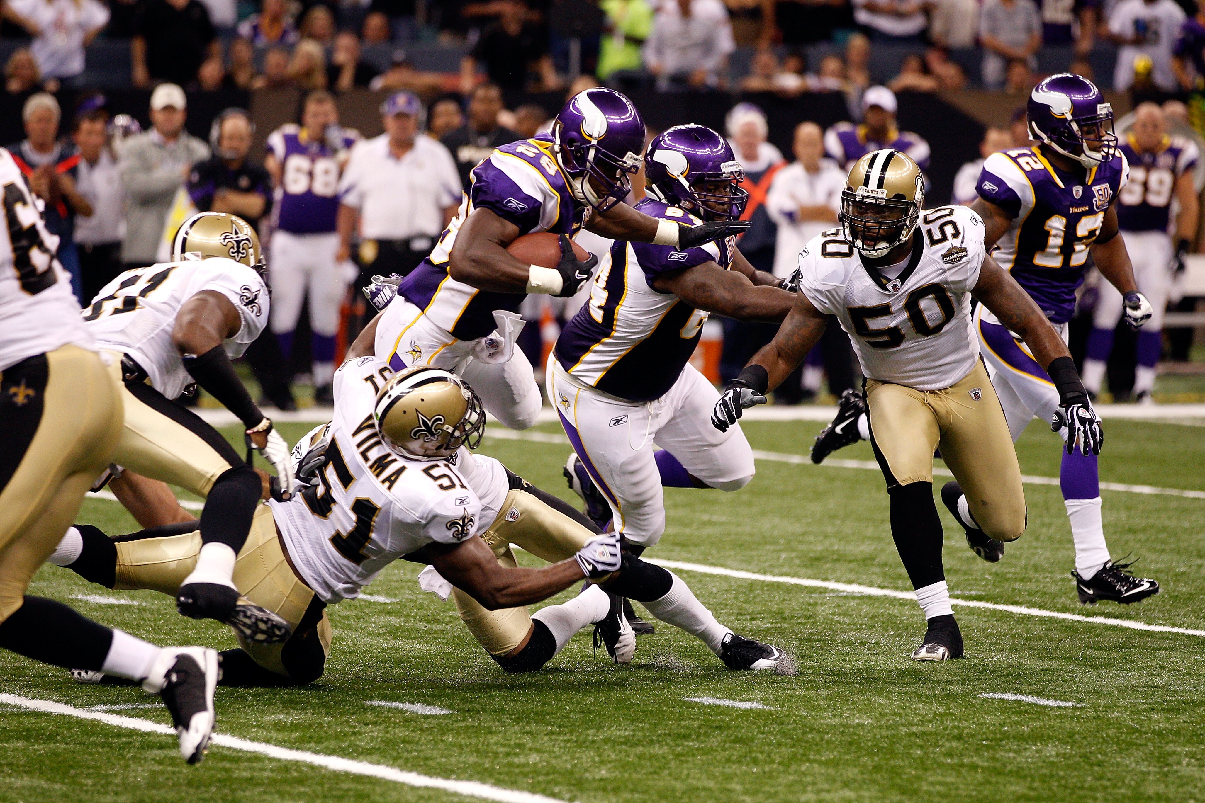 NEW ORLEANS - SEPTEMBER 09:  Adrian Peterson #28 of the Minnesota Vikings runs the ball against Jonathan Vilma #51 and Marvin Mitchell #50 of the New Orleans Saints at Louisiana Superdome on September 9, 2010 in New Orleans, Louisiana.  (Photo by Chris Gr