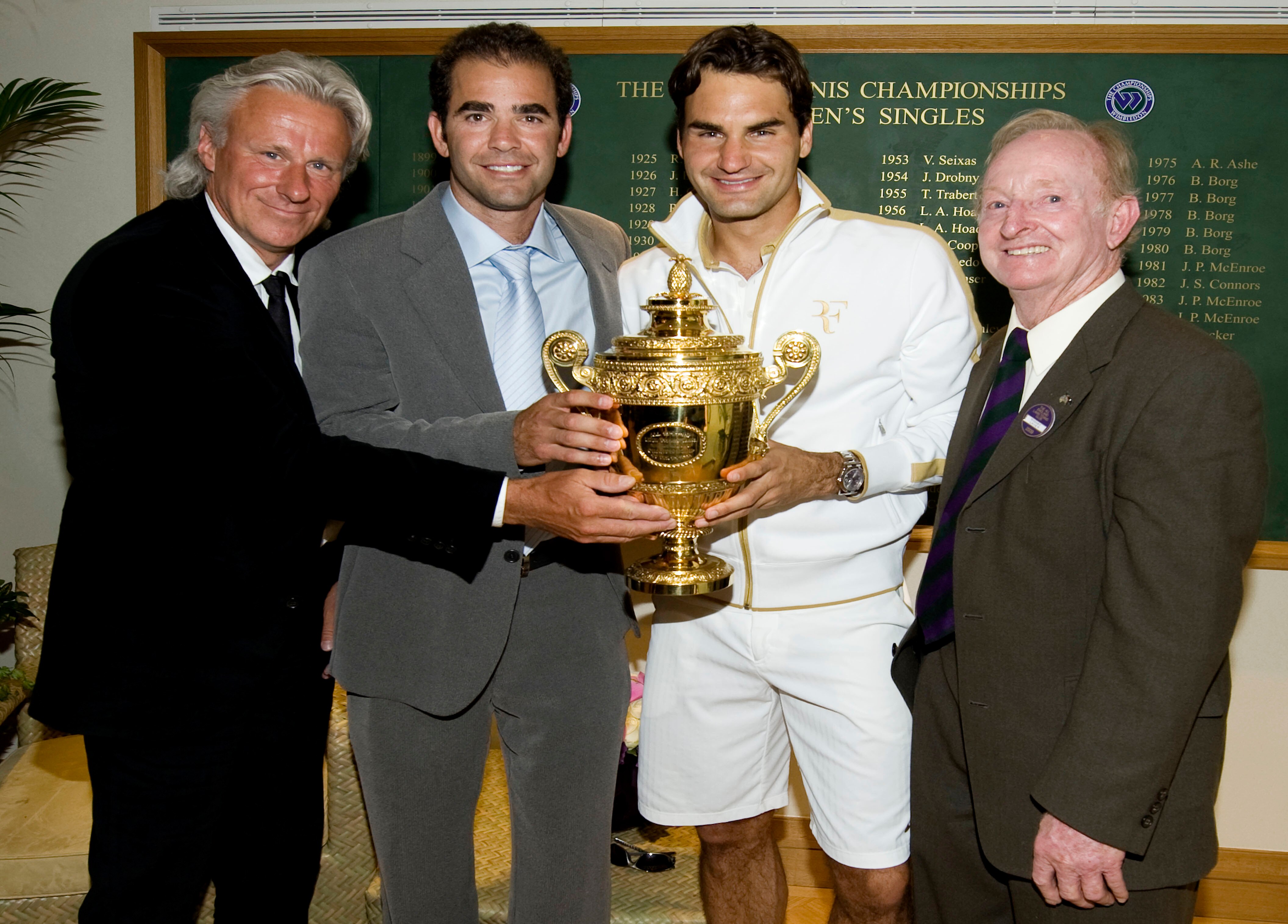 WIMBLEDON, ENGLAND - JULY 05:  Roger Federer of Switzerland (2R) celebrates with the trophy alongside Bjorn Borg (L), Pete Sampras (2L) and Rod Laver (R)  after the men's singles final match against Andy Roddick of USA on Day Thirteen of the Wimbledon Law