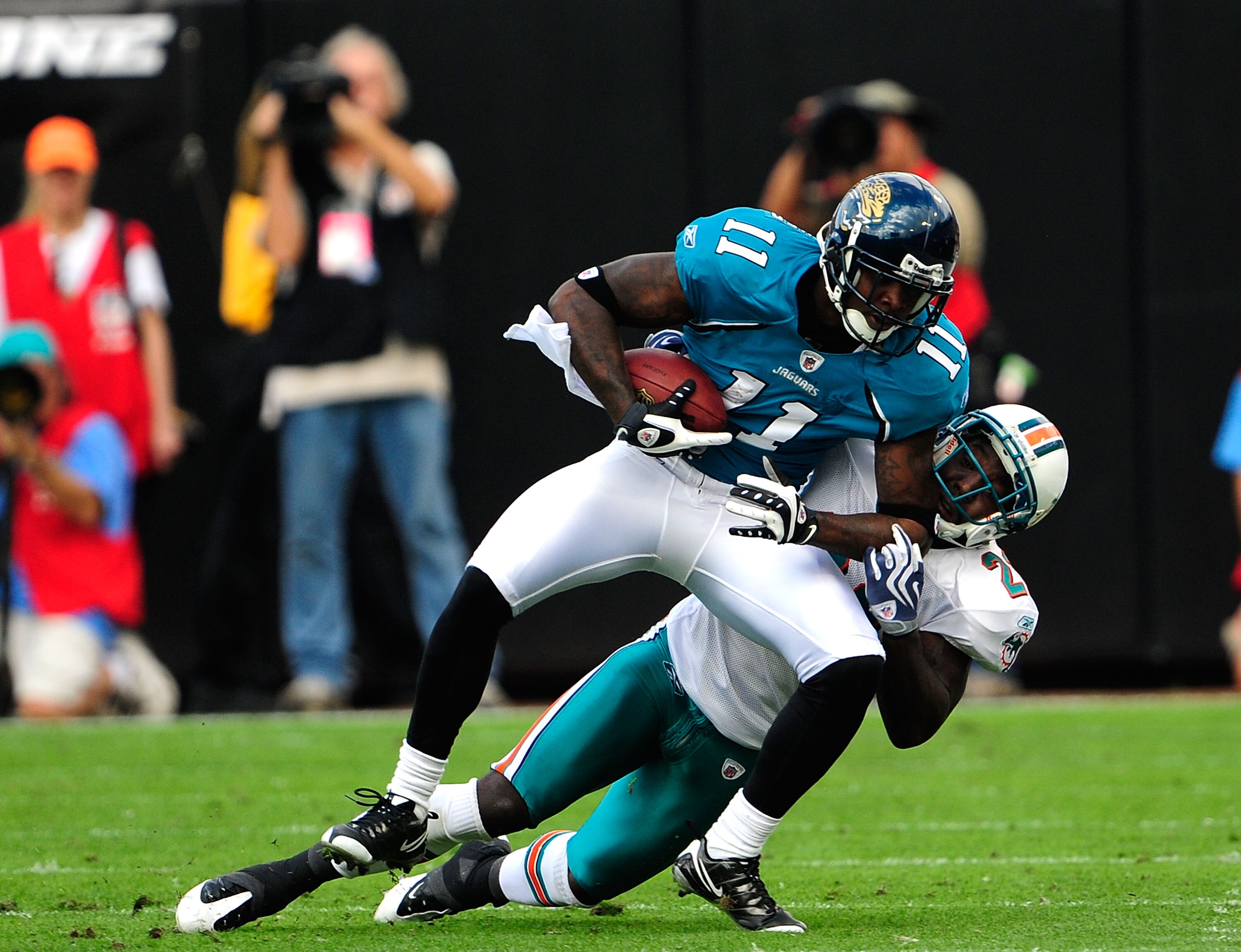 JACKSONVILLE, FL - DECEMBER 13:  Mike Sims-Walker #11 of the Jacksonville Jaguars is tackled by Gibril Wilson #28 of the Miami Dolphins during the game at Jacksonville Municipal Stadium on December 13, 2009 in Jacksonville, Florida.  The Dolpnins won 14-1