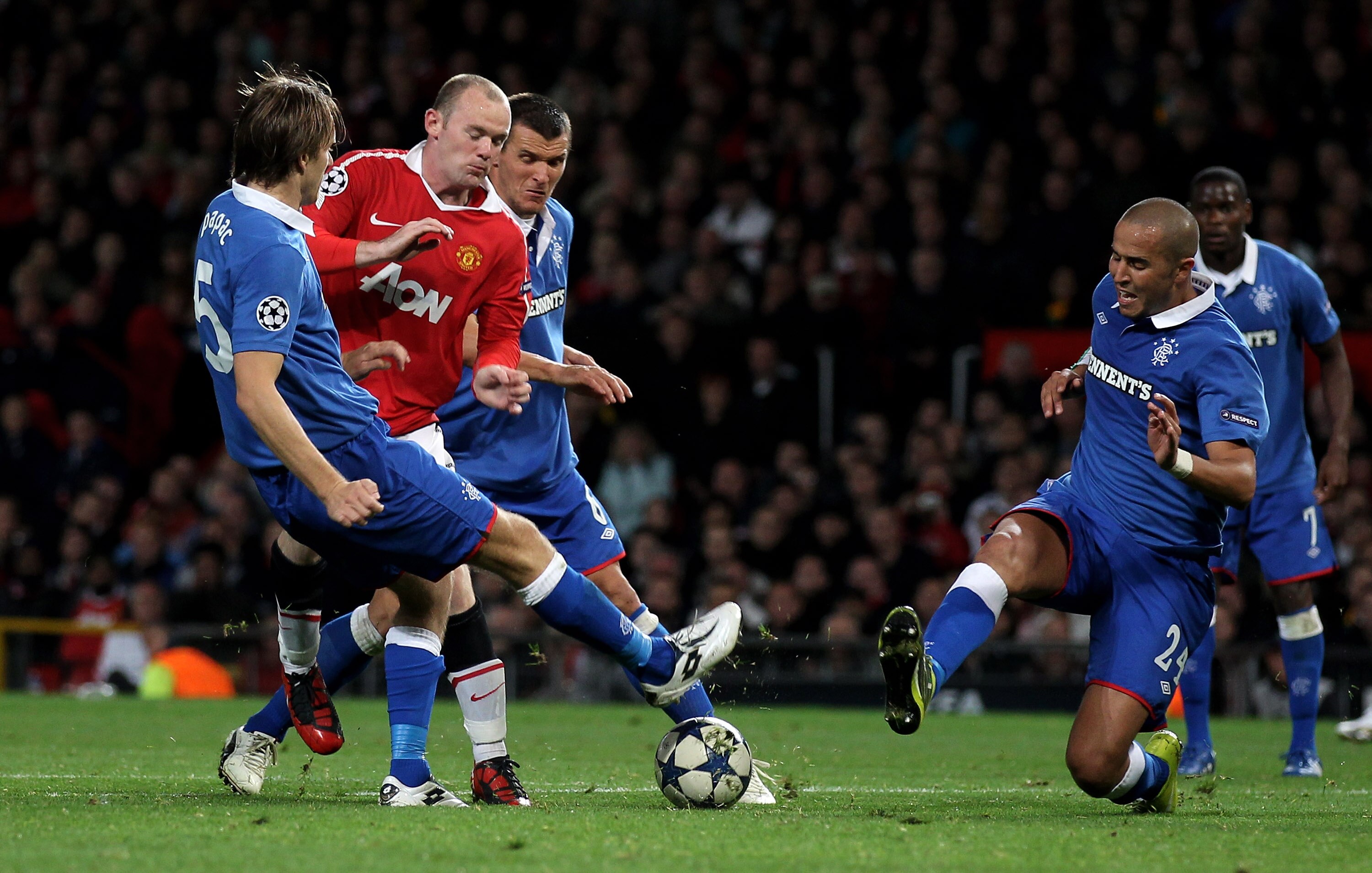 MANCHESTER, ENGLAND - SEPTEMBER 14:  Wayne Rooney of Manchester United is challenged by Madjid Bougherra (R) of Rangers during the UEFA Champions League Group C match between Manchester United and Rangers at Old Trafford on September 14, 2010 in Mancheste