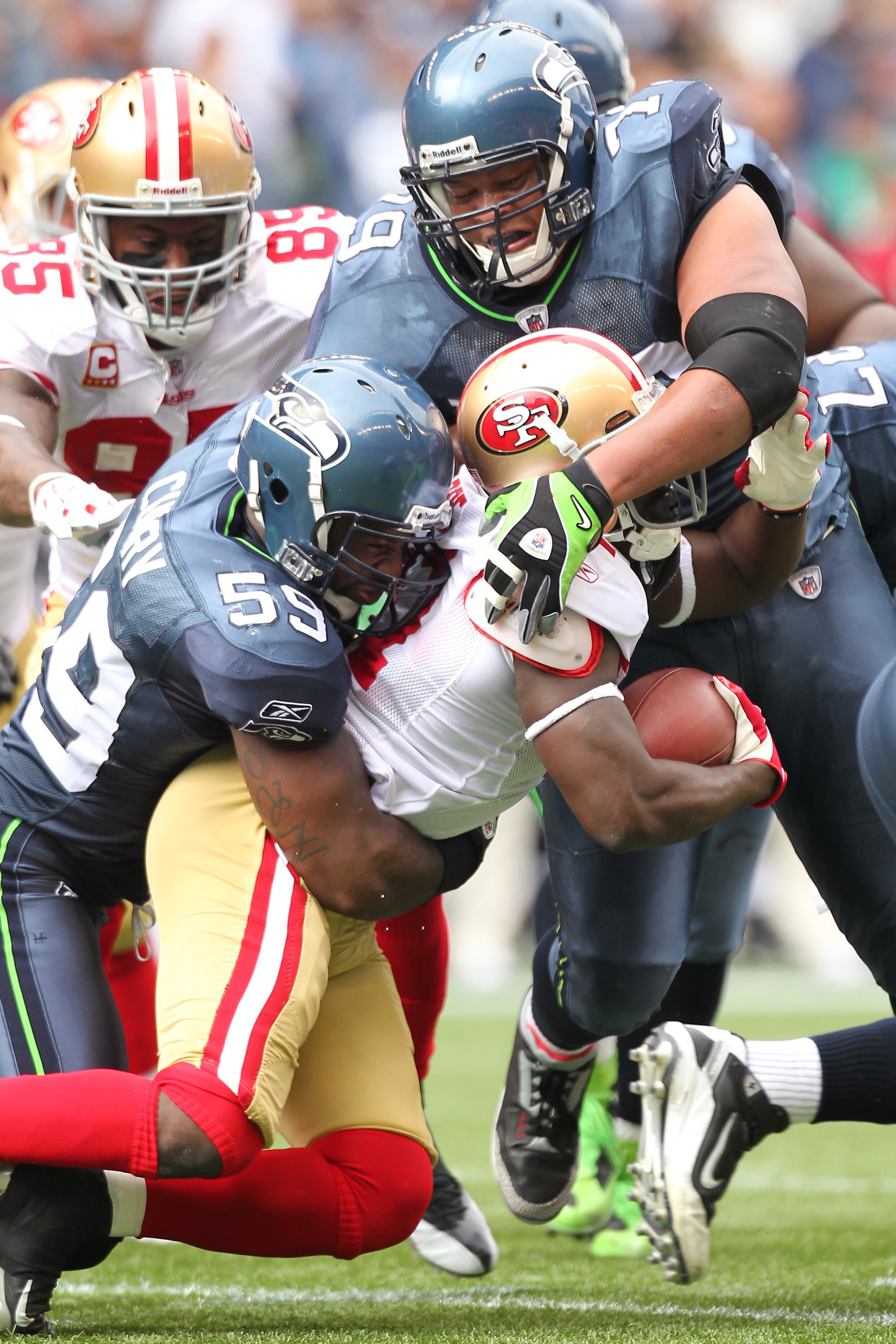 SEATTLE - SEPTEMBER 12:  Running back Frank Gore #21 of the San Francisco 49ers is tackled by Aaron Curry #59 and Red Bryant #79 of the Seattle Seahawks during the NFL season opener at Qwest Field on September 12, 2010 in Seattle, Washington. (Photo by Ot