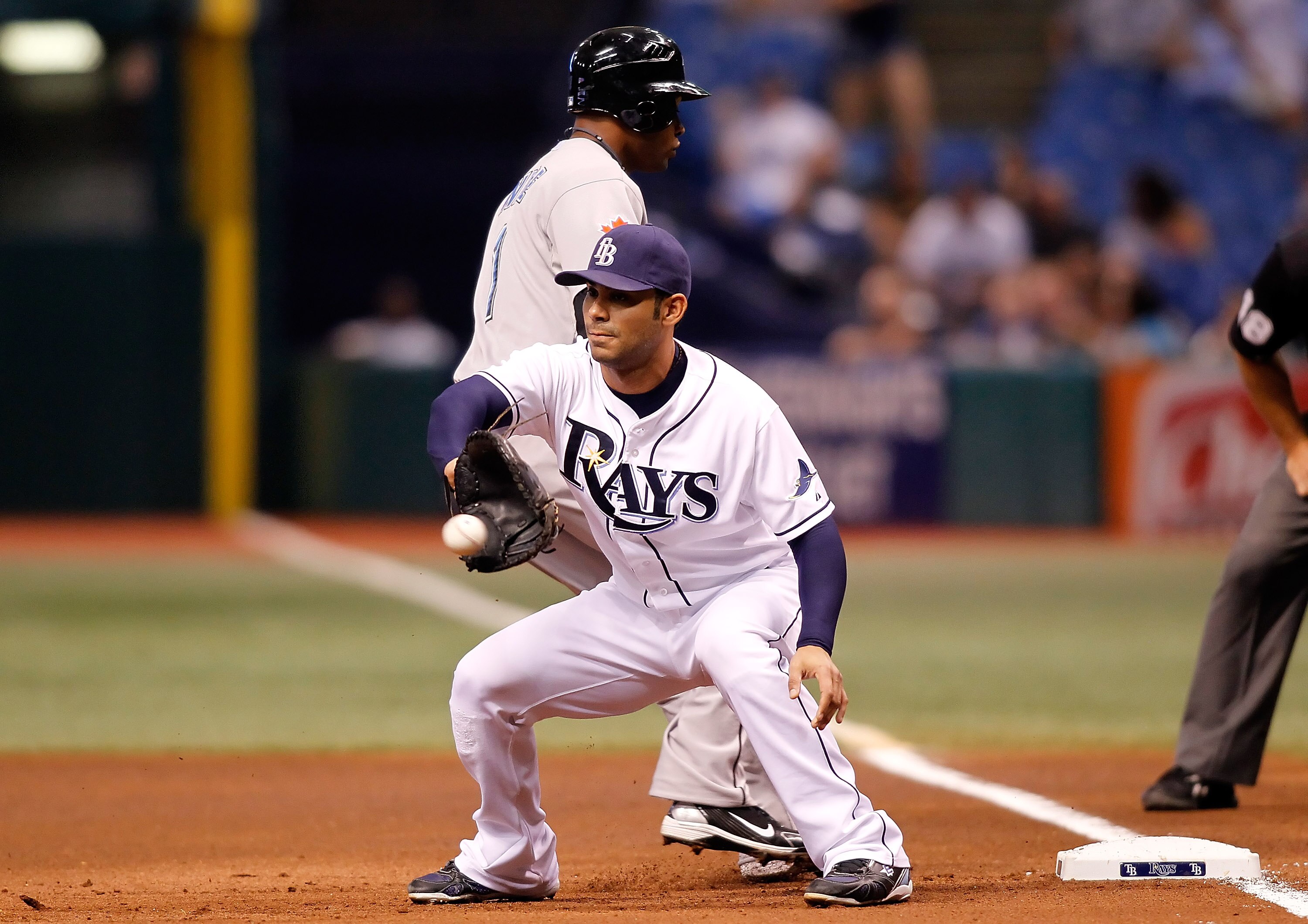 ST. PETERSBURG - AUGUST 31:  First baseman Carlos Pena #23 of the Tampa Bay Rays takes the throw at first as DeWayne Wise #1 of the Toronto Blue Jays gets back safely during the game at Tropicana Field on August 31, 2010 in St. Petersburg, Florida.  (Phot