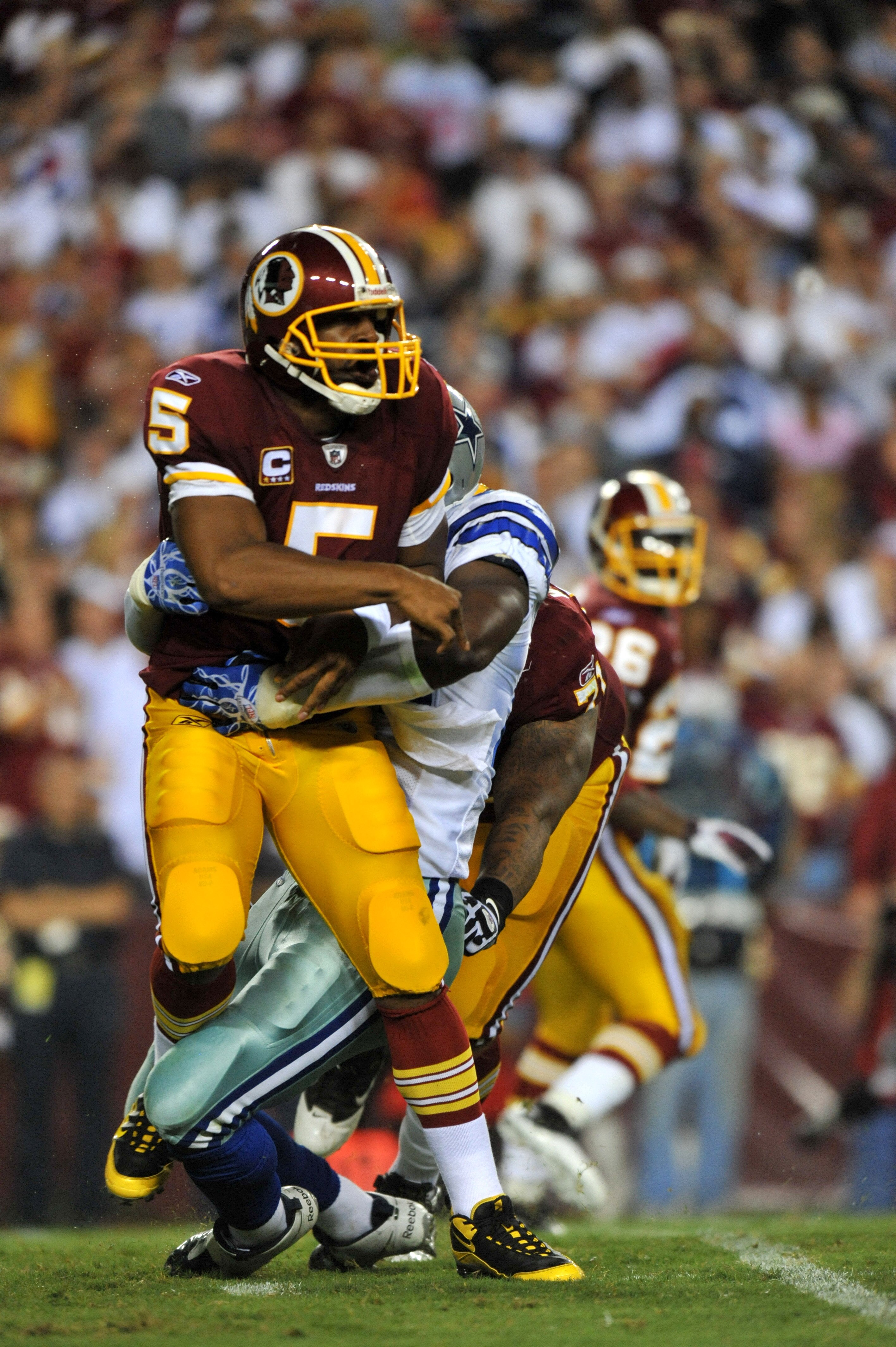 LANDOVER - SEPTEMBER 12:  Donovan McNabb #5 of the Washington Redskins throws under pressure during the NFL season opener against the Dallas Cowboys at FedExField on September 12, 2010 in Landover, Maryland. The Redskins defeated the Cowboys 13-7. (Photo
