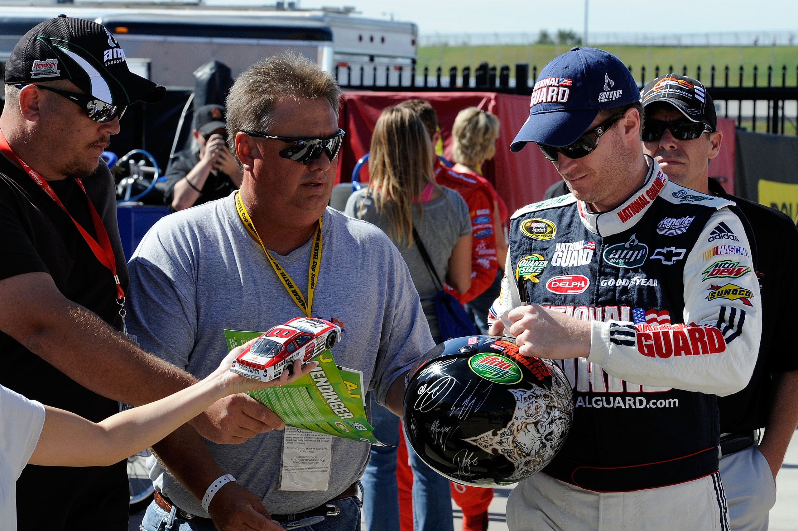 HAMPTON, GA - SEPTEMBER 04:  Dale Earnhardt Jr. (R), driver of the #88 AMP Energy/National Guard Chevrolet, signs his autograph for fans during practice for the NASCAR Sprint Cup Series Emory Healthcare 500 at Atlanta Motor Speedway on September 4, 2010 i