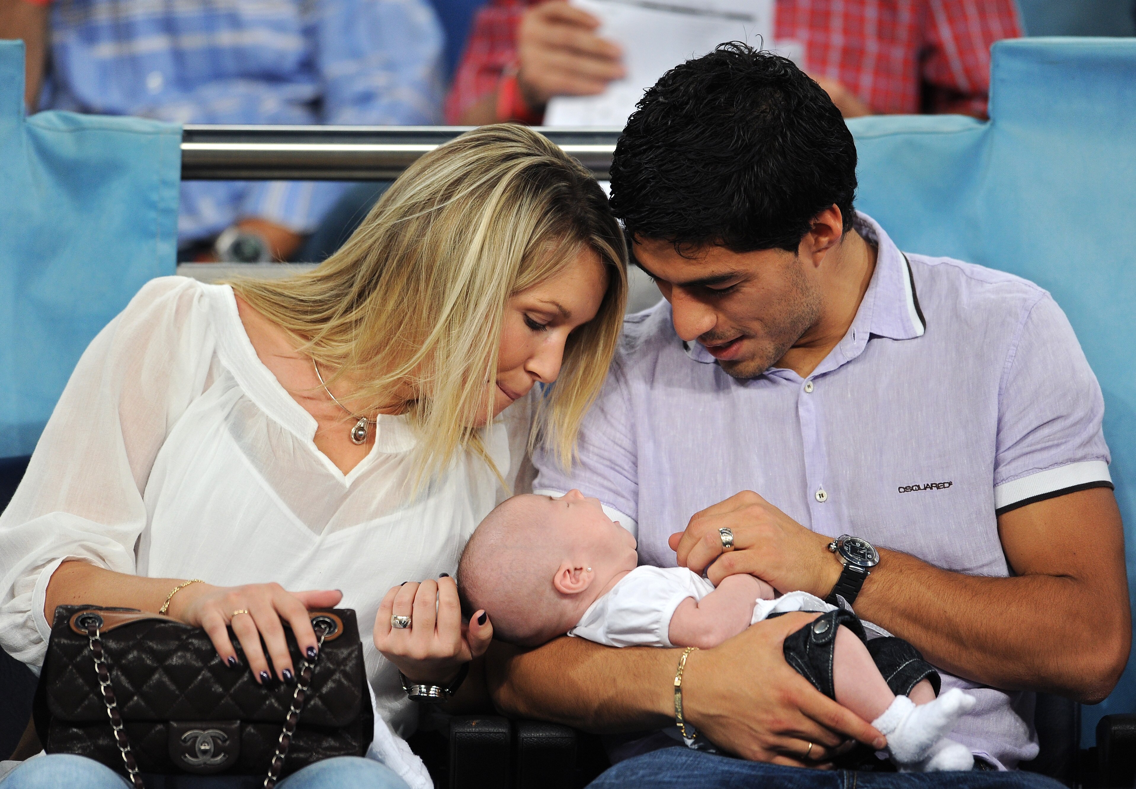 MADRID, SPAIN - SEPTEMBER 15: Expelled Ajax player Luis Suarez (R) hold his baby daughter Delfina while seated next to his wife Sofia prior to the start of the UEFA Champions League group G match between Real Madrid and Ajax at the Estadio Santiago Bernab