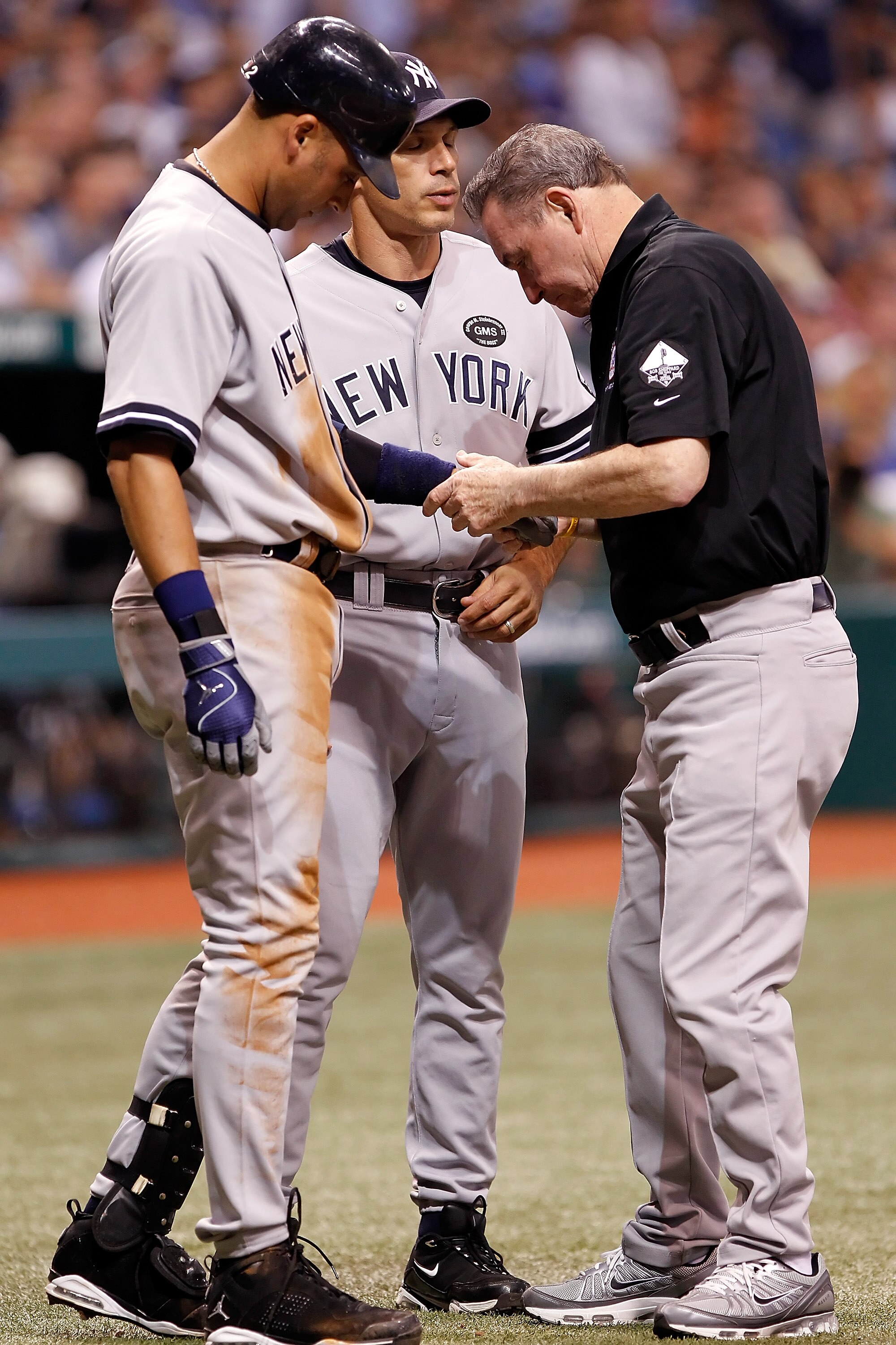 ST. PETERSBURG, FL - SEPTEMBER 15:  Shortstop Derek Jeter #2 (R) of the New York Yankees is examined by the team trainer, with manager Joe Girardi looking on, after he is allegedly hit by a pitch during the game against the Tampa Bay Rays at Tropicana Fie