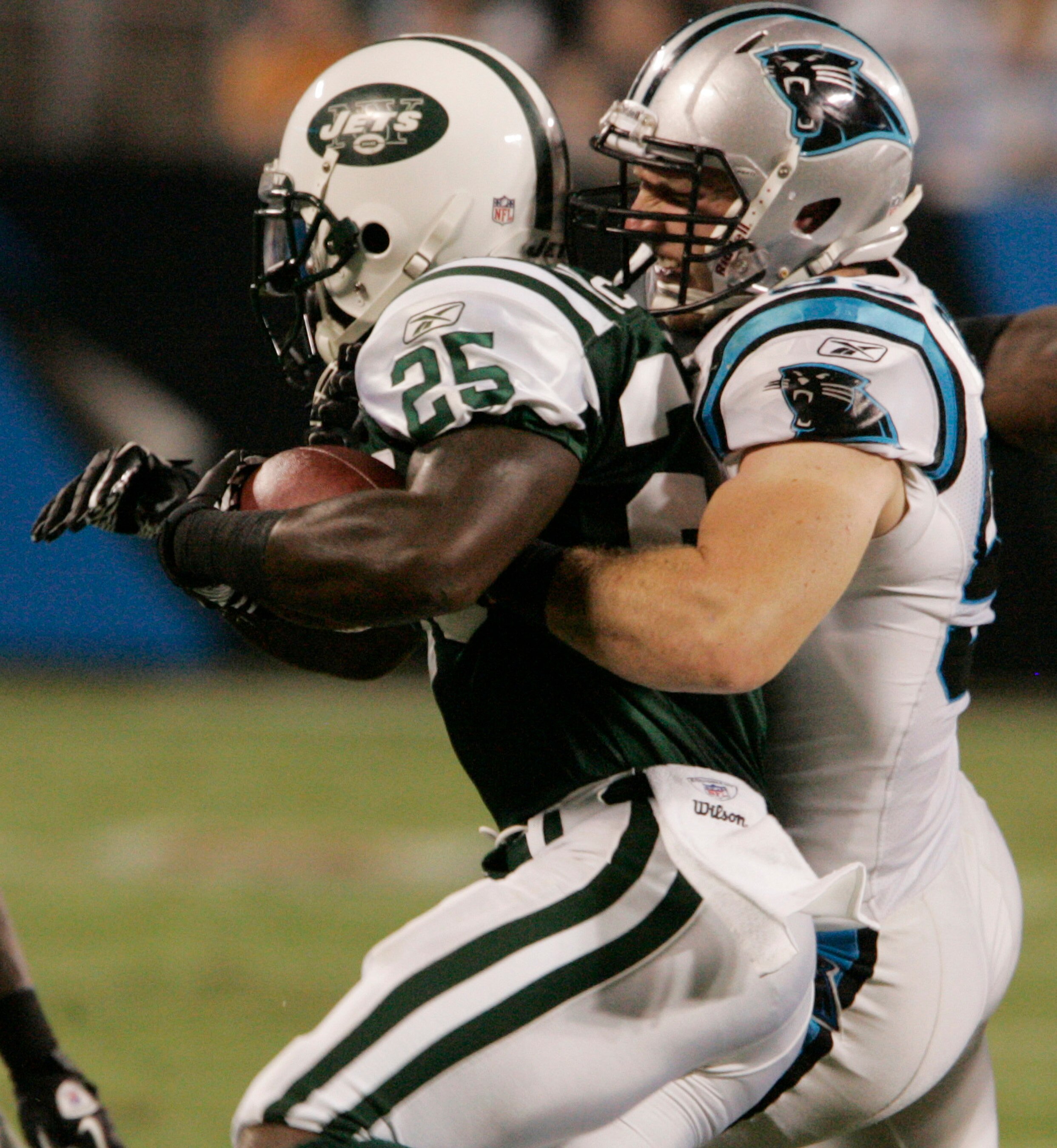 CHARLOTTE, NC - AUGUST 21:   Linebacker Dan Connor #55 of the Carolina Panthers grabs Joe McKnight #25 of the New York Jets on a kick return during their preseason game at Bank of America Stadium on August 21, 2010 in Charlotte, North Carolina. (Photo by 