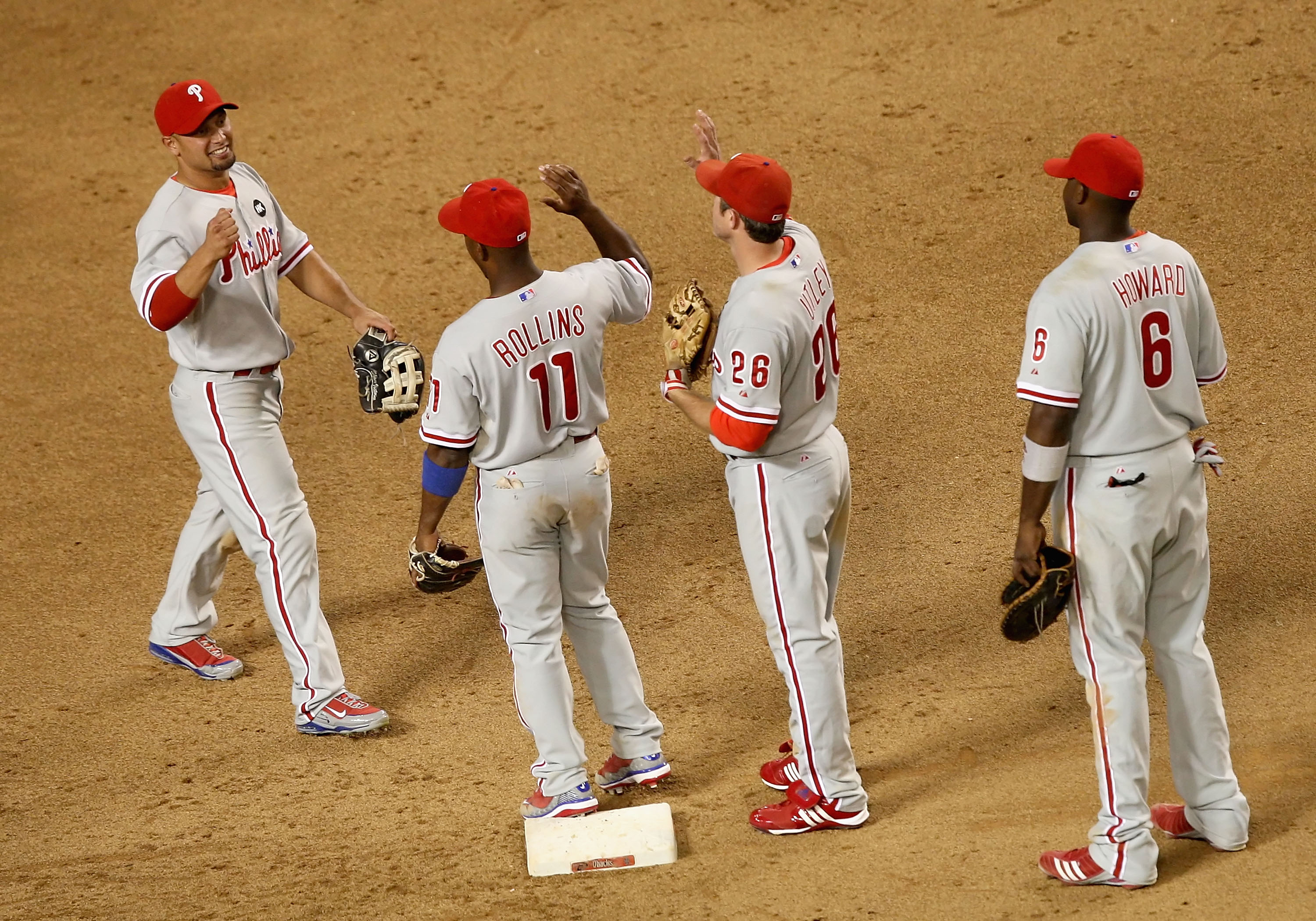 PHOENIX - JULY 28:  (L-R) Shane Victorino #8 of the Philadelphia Phillies celebrates with teammates Jimmy Rollins #11, Chase Utley #26 and Ryan Howard #6 after defeating the Arizona Diamondbacks during the major league baseball game at Chase Field on July