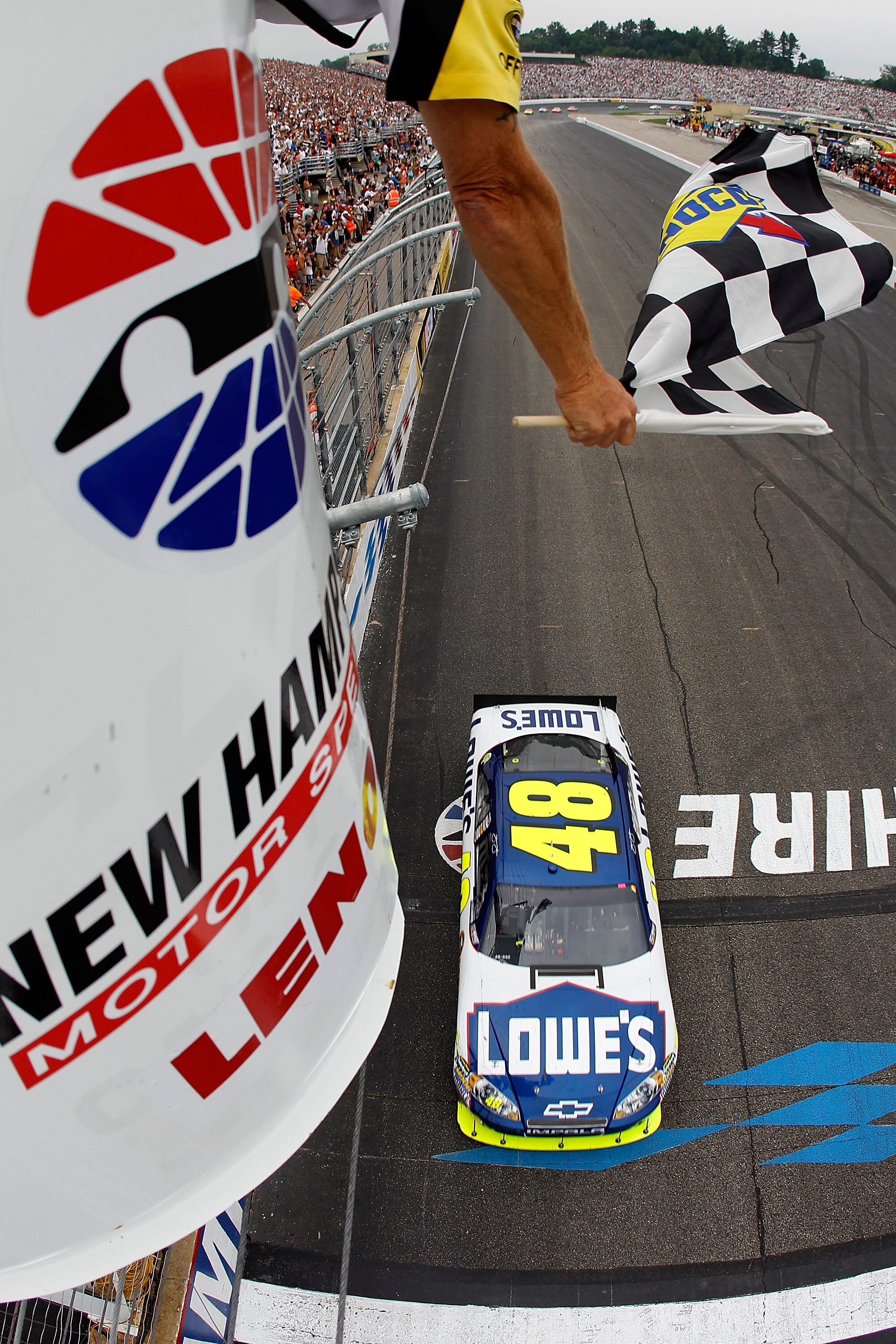 LOUDON, NH - JUNE 27:  Jimmie Johnson, driver of the #48 Lowe's Chevrolet, takes the checkered flag to win the NASCAR Sprint Cup Series LENOX Industrial Tools 301 at New Hampshire Motor Speedway on June 27, 2010 in Loudon, New Hampshire.  (Photo by Todd W