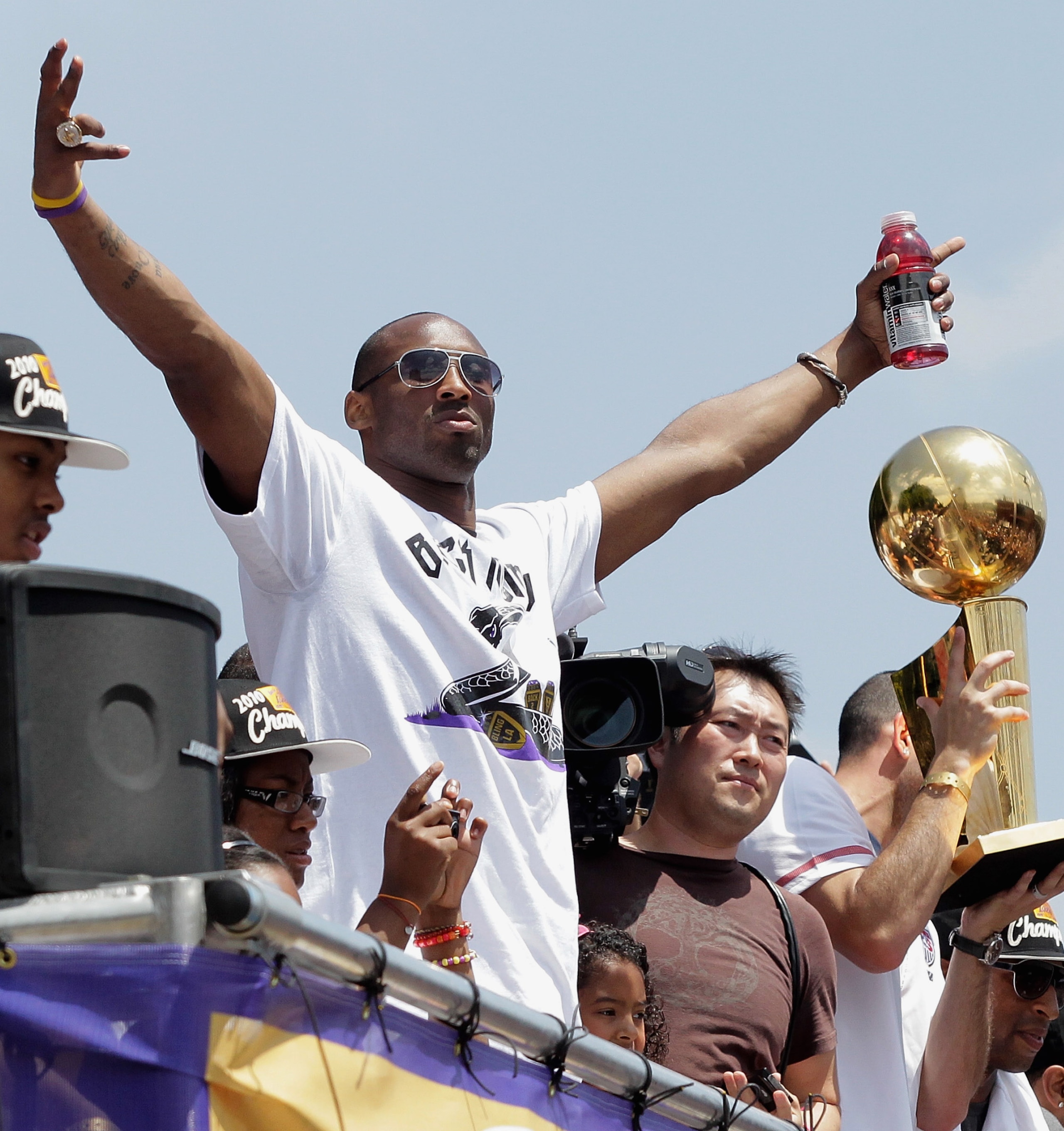 LOS ANGELES, CA - JUNE 21:  Los Angeles Lakers guard Kobe Bryant (L) waves to the crowd while riding in the victory parade for the the NBA basketball champion team on June 21, 2010 in Los Angeles, California. The Lakers beat the Boston Celtics 87-79 in 7 