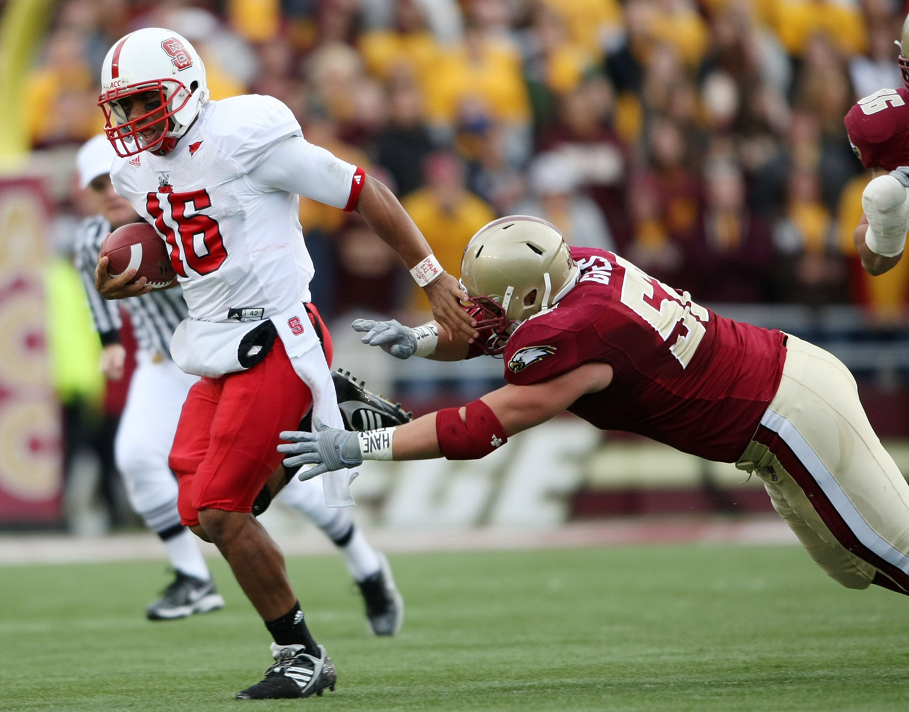 CHESTNUT HILL, MA - OCTOBER 17:  Russell Wilson #16 of the North Carolina State Wolf Pack  scrambles as Austin Giles #52 of the Boston College Eagles defends on October 17, 2009 at Alumni Stadium in Chestnut Hill, Massachusetts.  (Photo by Elsa/Getty Imag