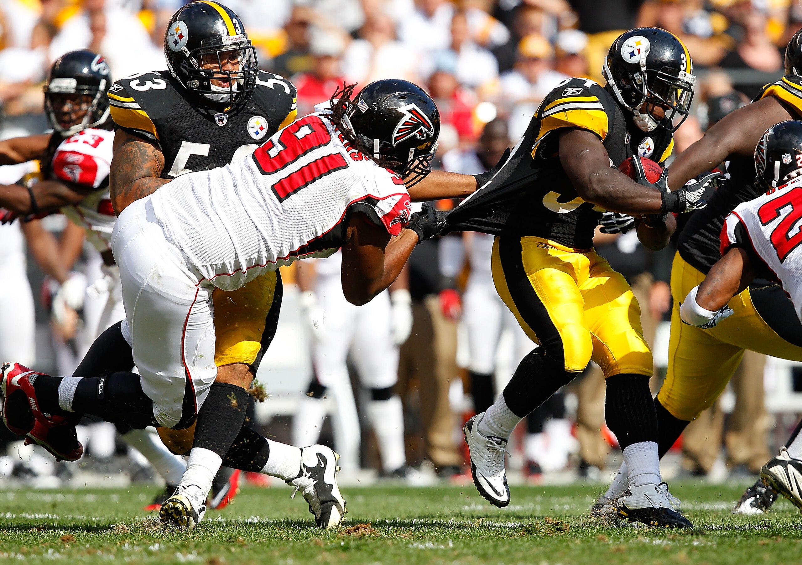 PITTSBURGH - SEPTEMBER 12:  Rashard Mendenhall #34 of the Pittsburgh Steelers tries to run out of the grasp of Corey Peters #91 of the Atlanta Falcons during the NFL season opener game on September 12, 2010 at Heinz Field in Pittsburgh, Pennsylvania.  (Ph