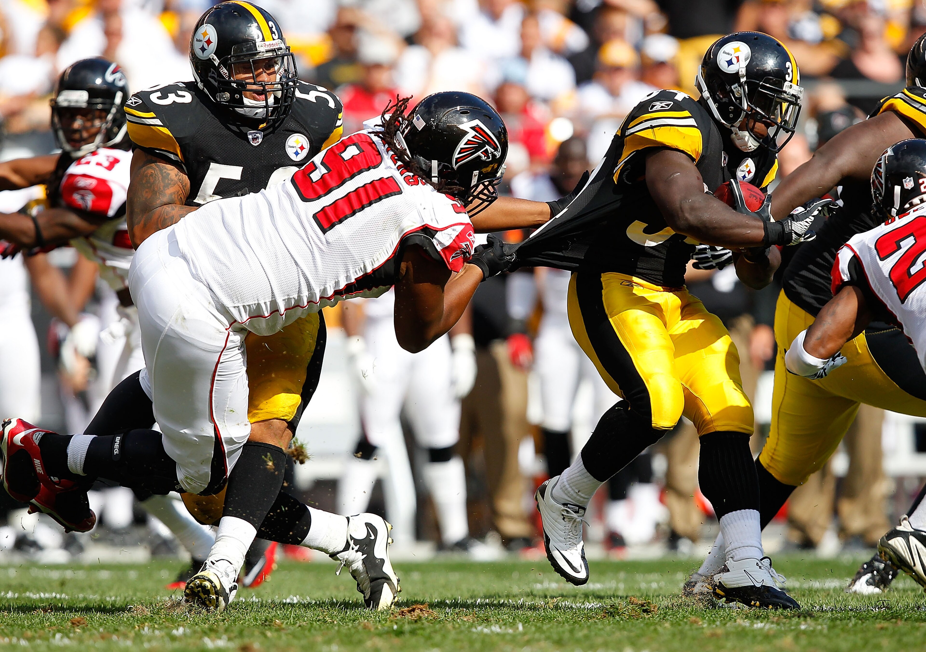 PITTSBURGH - SEPTEMBER 12:  Rashard Mendenhall #34 of the Pittsburgh Steelers tries to run out of the grasp of Corey Peters #91 of the Atlanta Falcons during the NFL season opener game on September 12, 2010 at Heinz Field in Pittsburgh, Pennsylvania.  (Ph