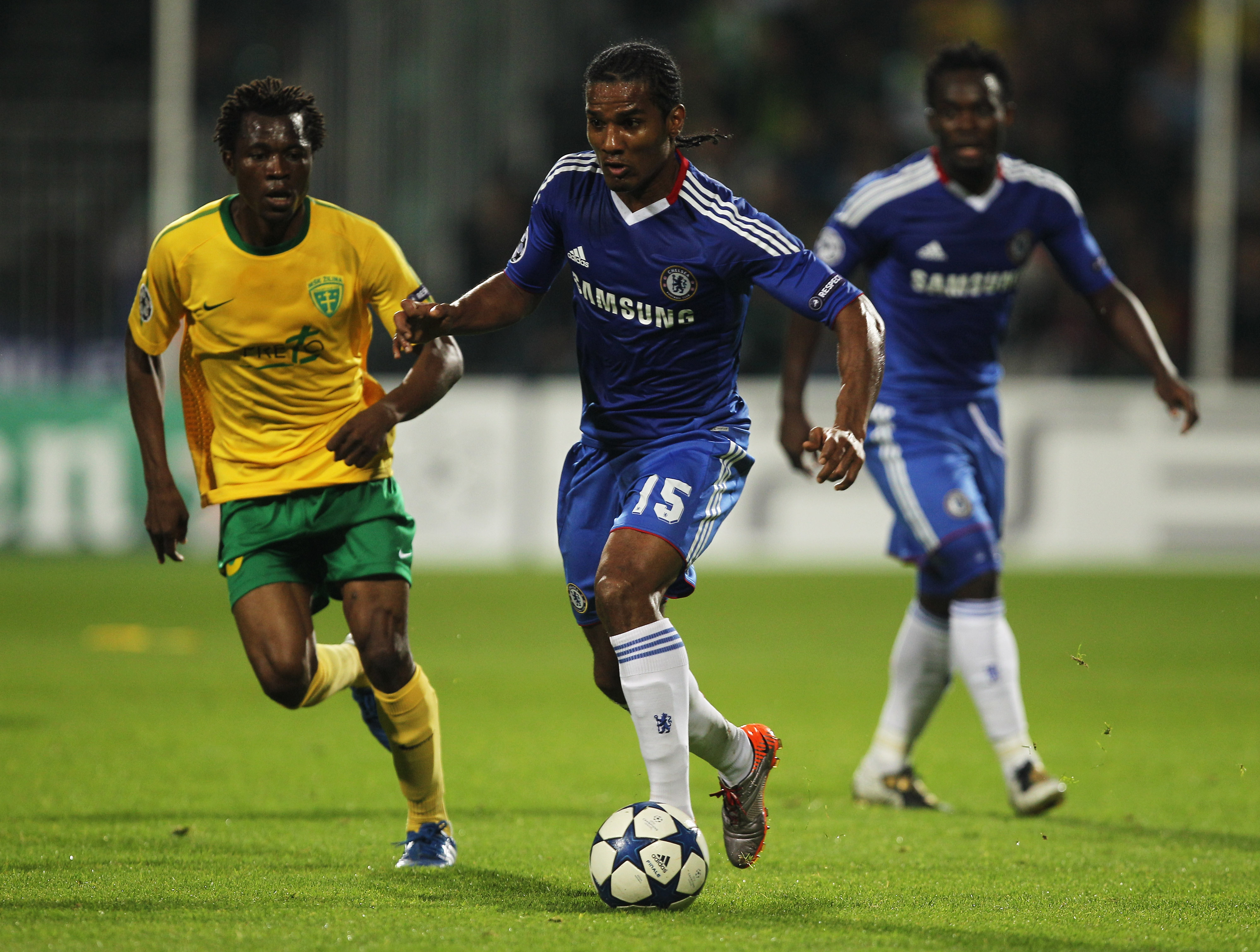 ZILINA, SLOVAKIA - SEPTEMBER 15:  Florent Malouda of Chelsea is chased by Babatounde Bello of MSK Zilina during the UEFA Champions League Group F match between MSK Zilina and Chelsea at the Pod Dubnom Stadium on September 15, 2010 in Zilina, Slovakia.  (P