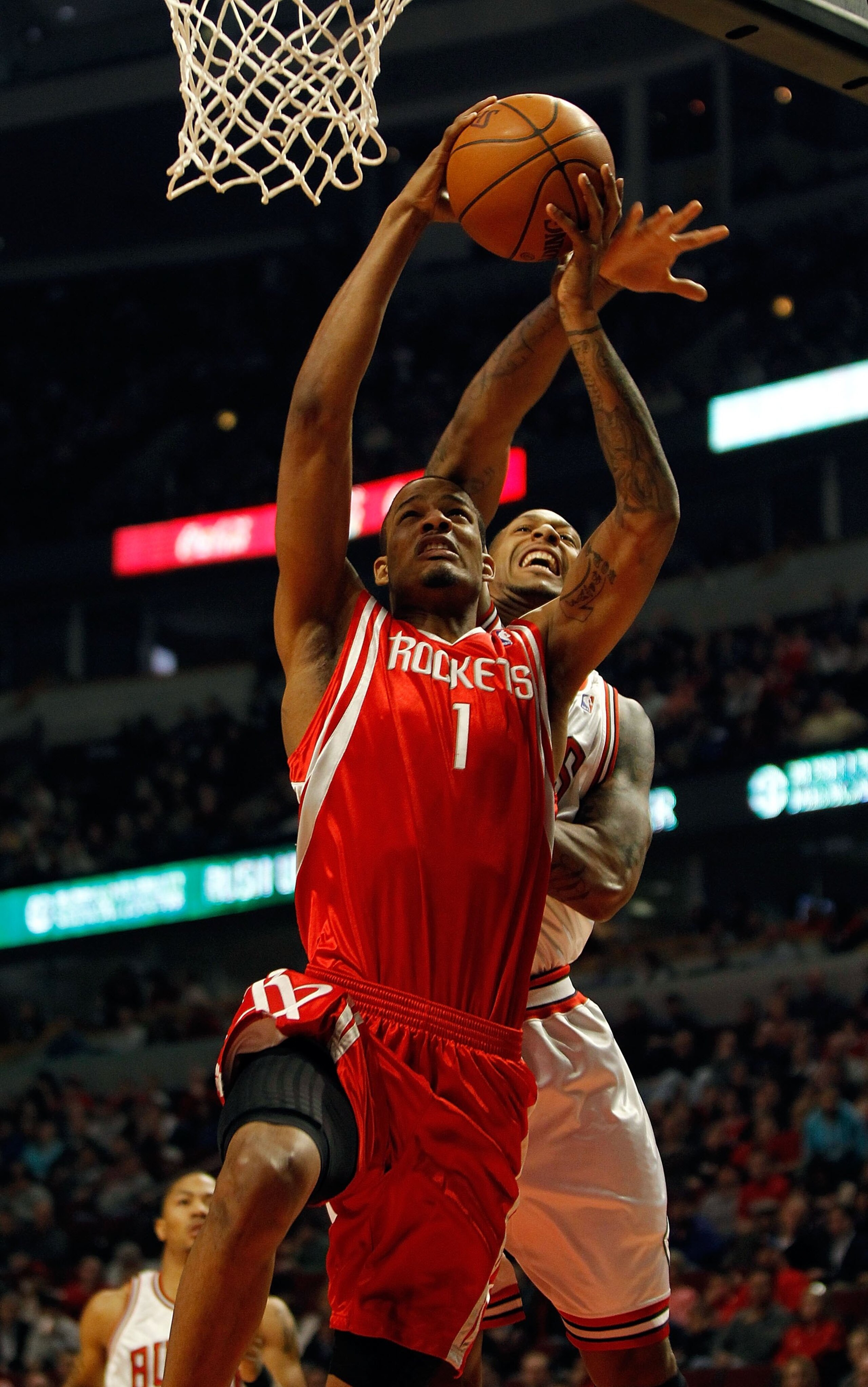 CHICAGO - MARCH 22: Trevor Ariza #1 of the Houston Rockets is fouled while shooting by James Johnson #16 of the Chicago Bulls at the United Center on March 22, 2010 in Chicago, Illinois. NOTE TO USER: User expressly acknowledges and agrees that, by downlo