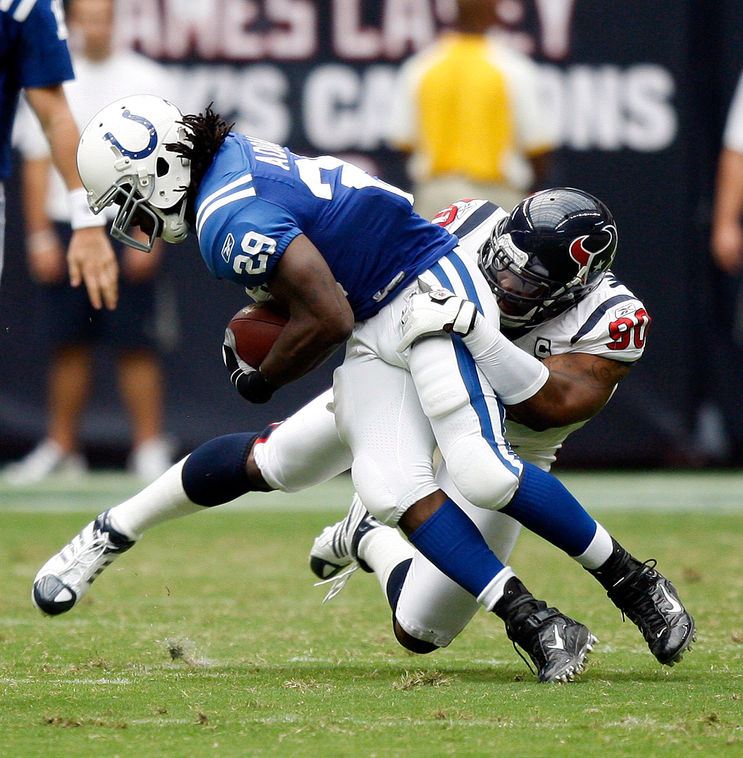 HOUSTON - SEPTEMBER 12:  Running back  Joseph Addai #29 of the Indianapolis Colts is tackled by defensive end Mario Williams #90 of the Houston Texans during the NFL season opener at Reliant Stadium on September 12, 2010 in Houston, Texas.  (Photo by Bob 
