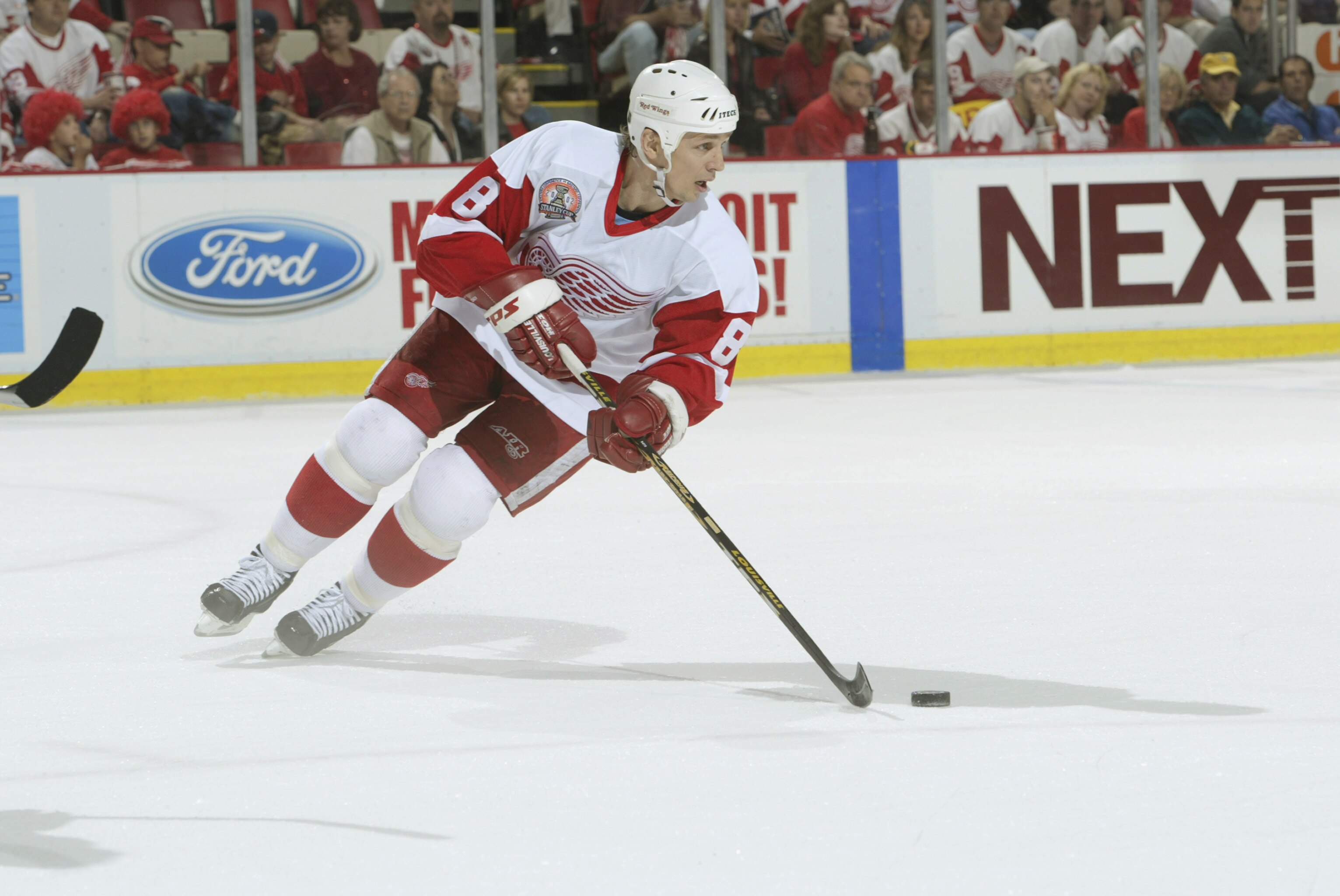 DETROIT, MI - JUNE 13:  Center Igor Larionov #8 of the Detroit Red Wings skates with the puck against the Carolina Hurricanes during game five of the NHL Stanley Cup Finals on June 13, 2002 at the Joe Louis Arena in Detroit, Michigan.  The Red Wings won 3